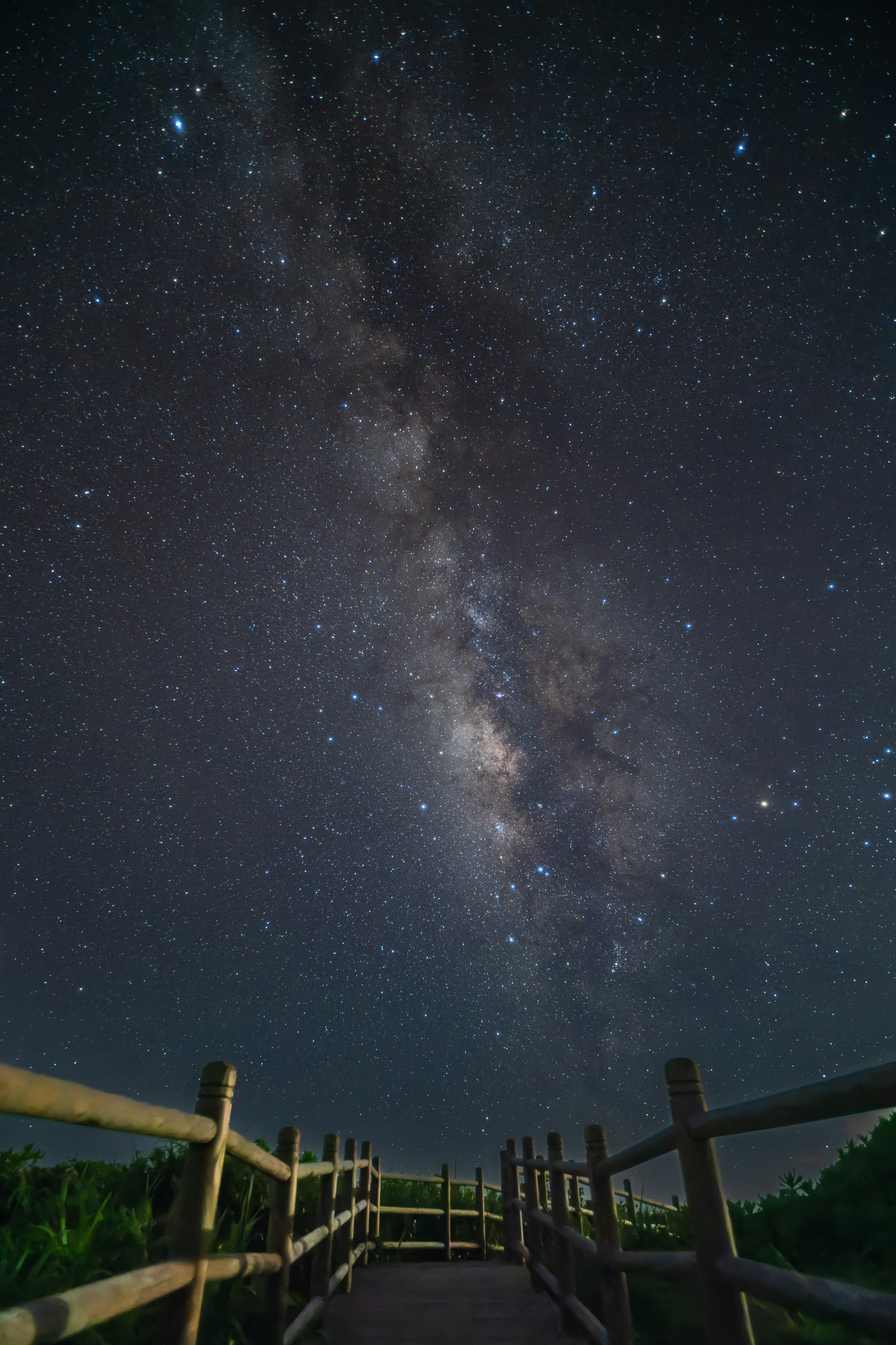 天の川が広がる夜空と柵のある展望