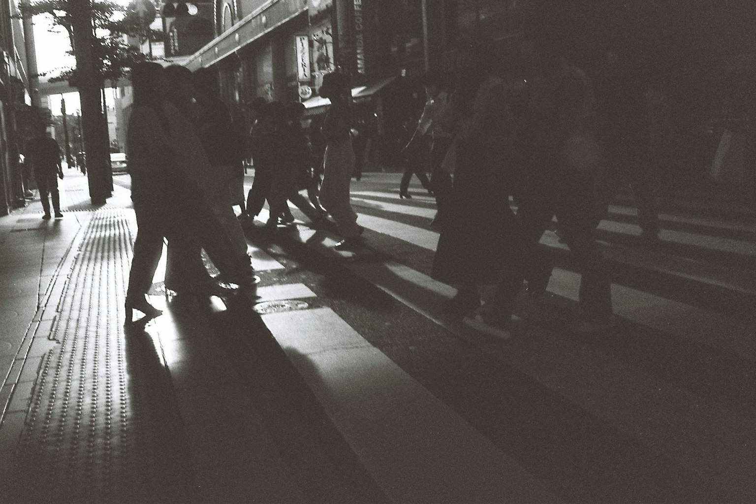 Scène urbaine en noir et blanc de personnes traversant un passage piéton