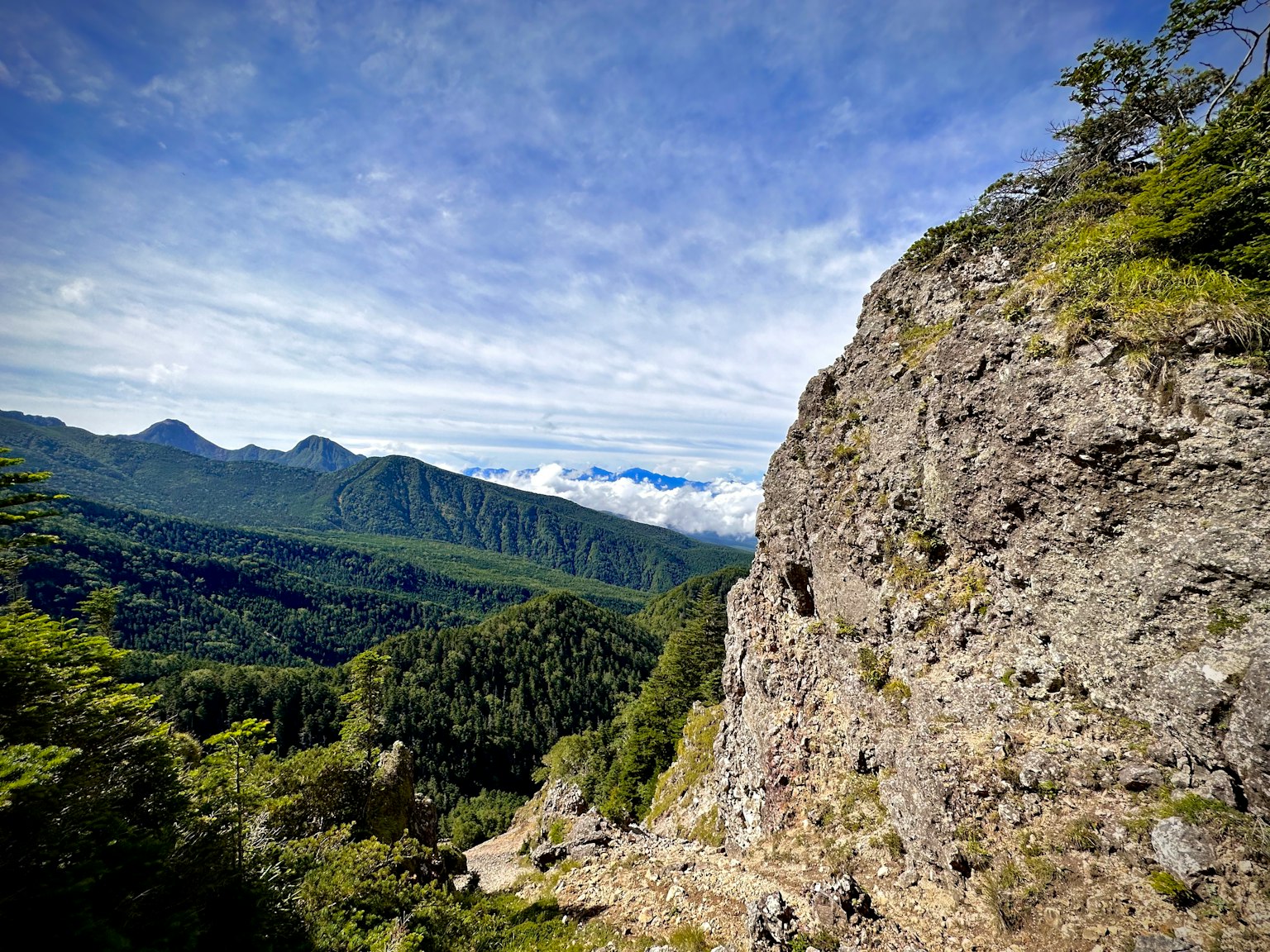 Pemandangan indah gunung dan langit biru dengan tebing batu dan vegetasi hijau