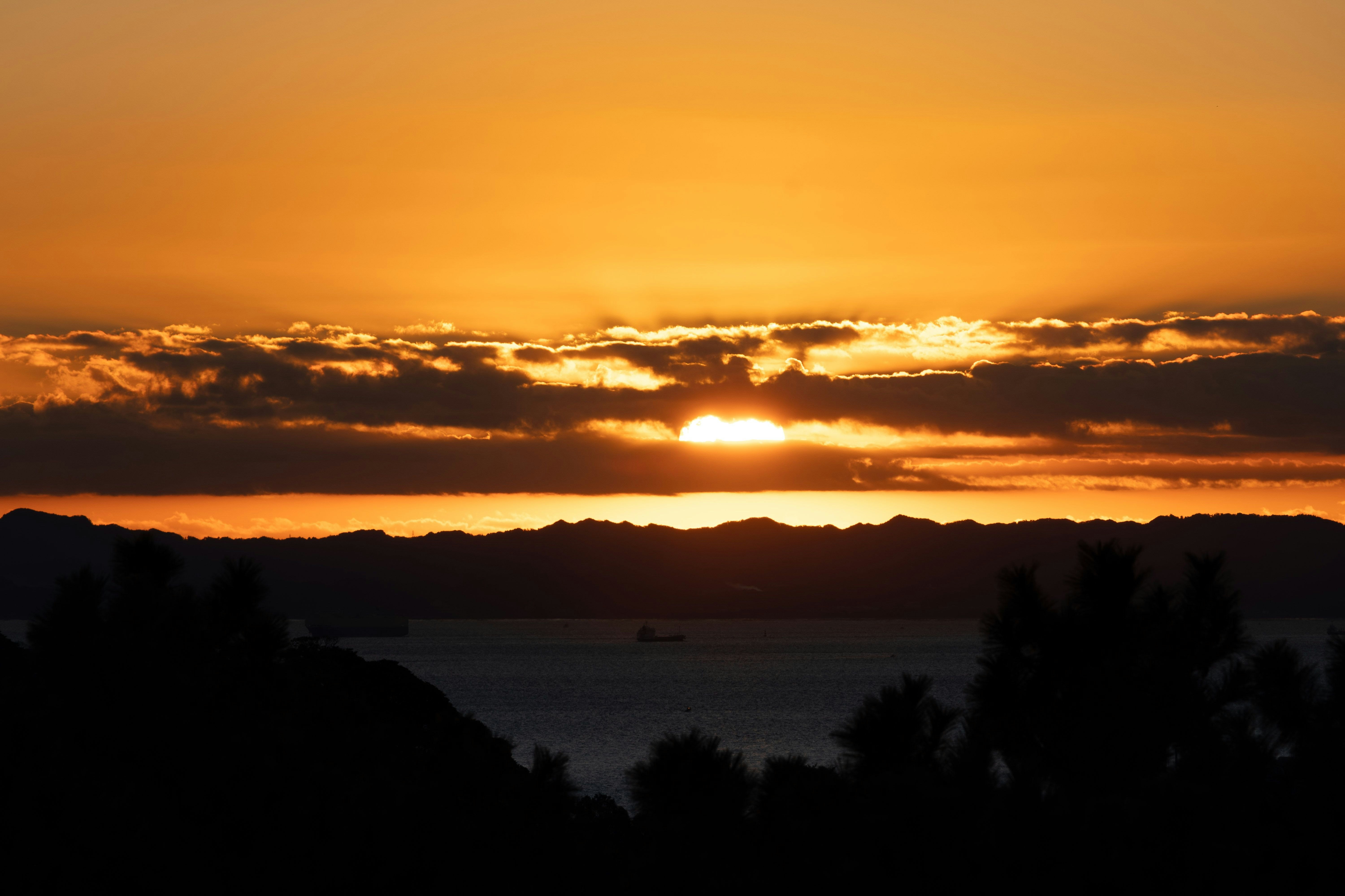 nuvole al tramonto sopra il mare con il sole vicino all’orizzonte