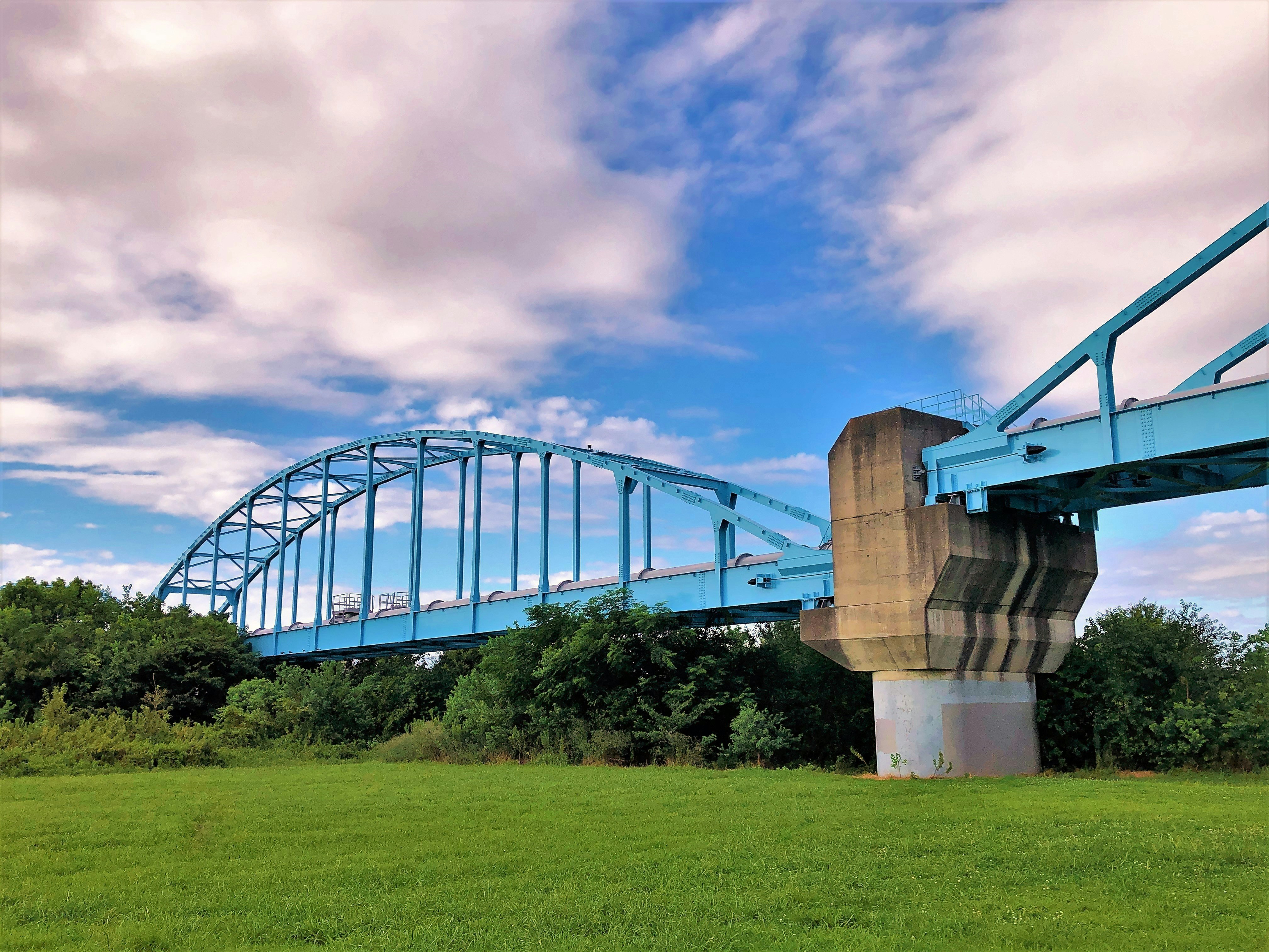 緑の草地と青いアーチ橋、コンクリートの橋脚