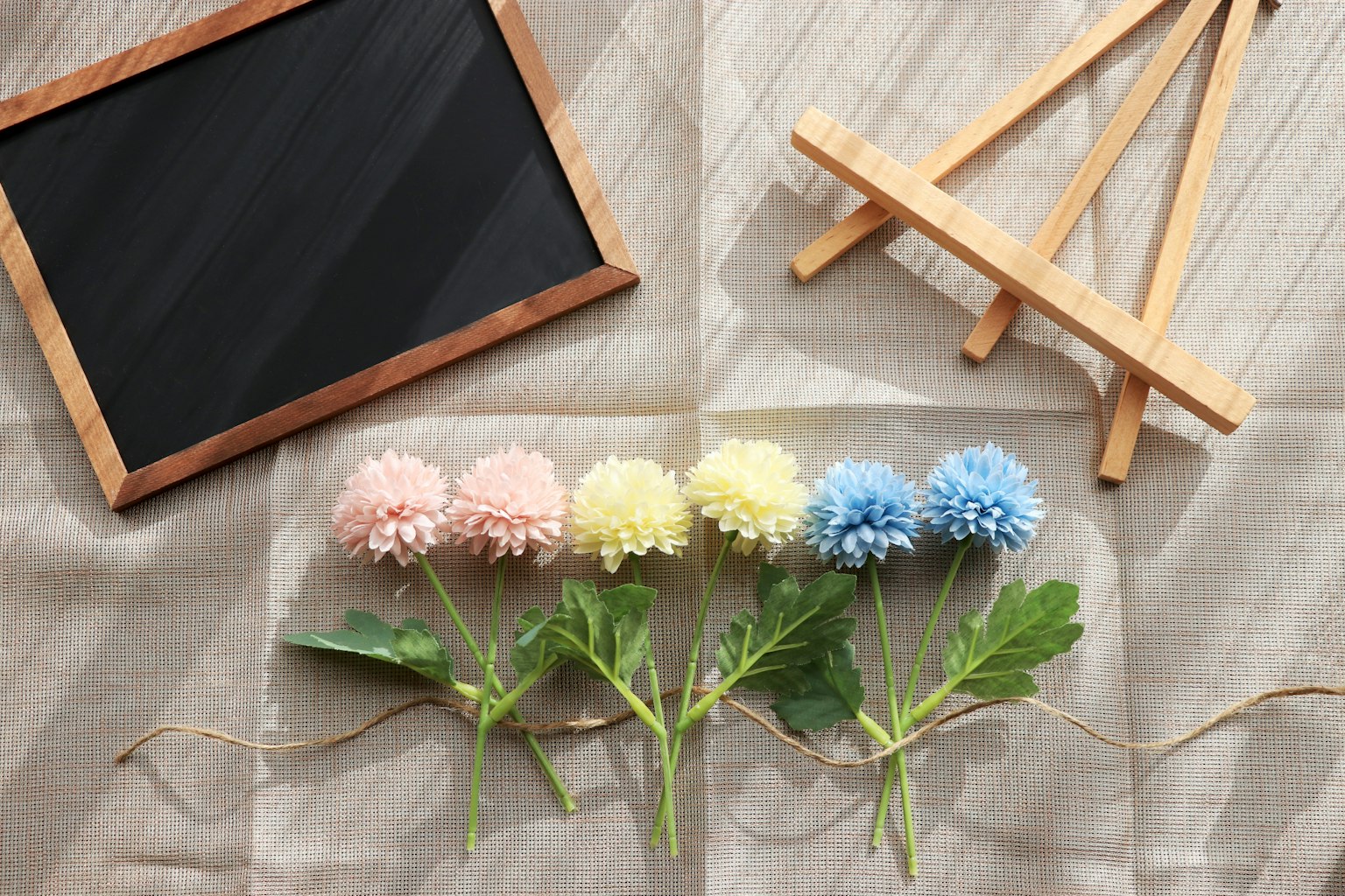 Colorful flowers arranged with a wooden easel and chalkboard