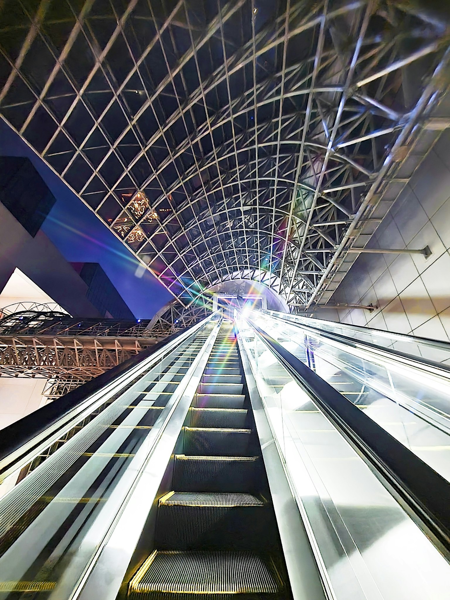 Futuristic escalator leading upwards with a geometric ceiling
