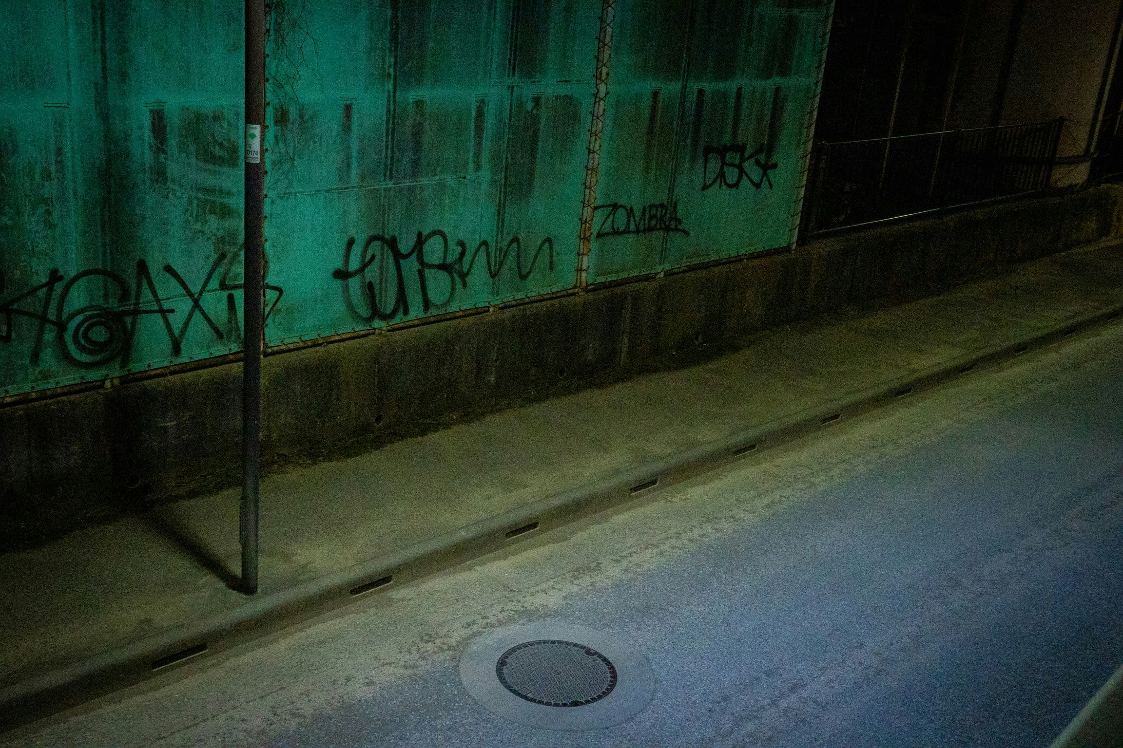 夜の路上にある壁の落書きと街灯の光