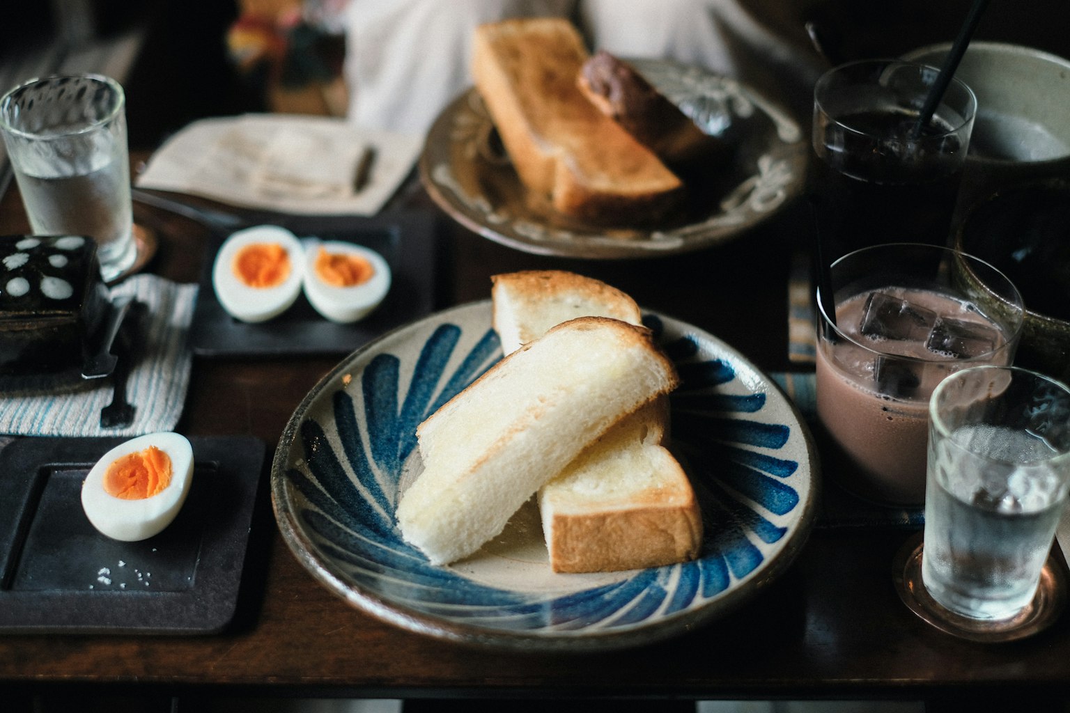 Sliced white bread and soft-boiled eggs on a blue plate