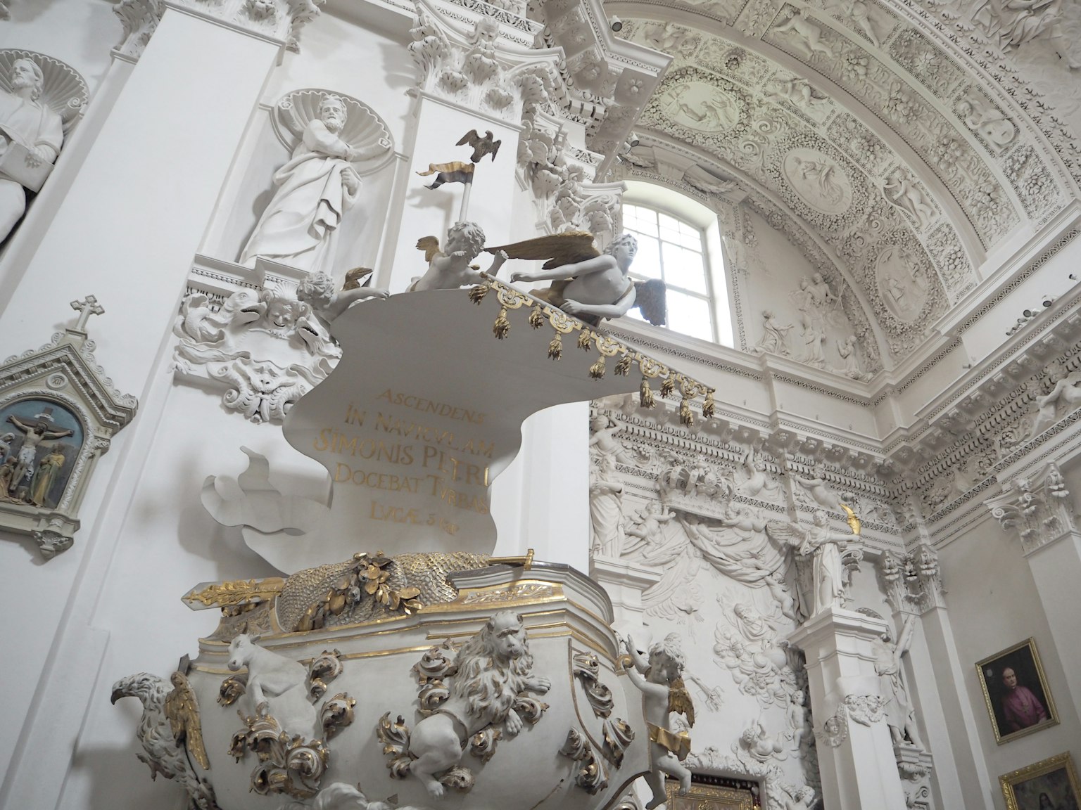 Intérieur d'une église avec une fontaine blanche ornée et un plafond somptueux