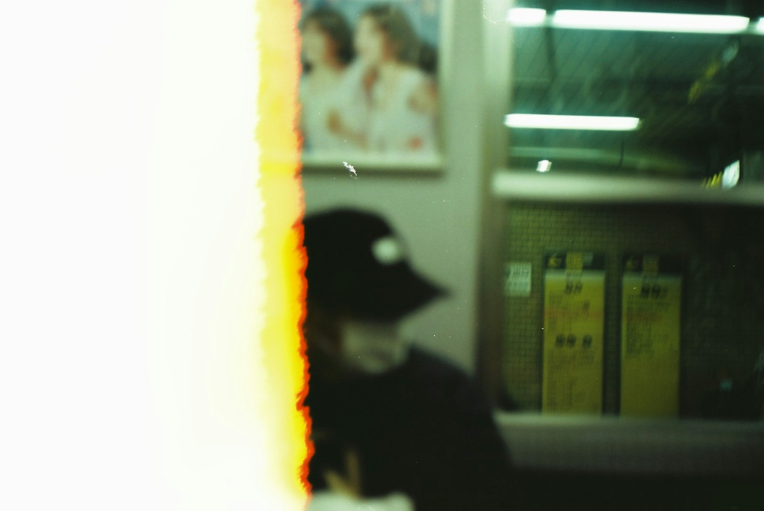 Figura sfocata con un cappello nero seduta in un treno