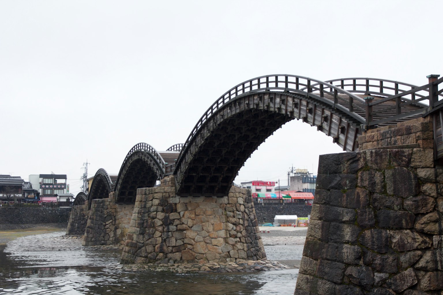 Pont en arc en pierre avec une structure en bois au-dessus de l'eau
