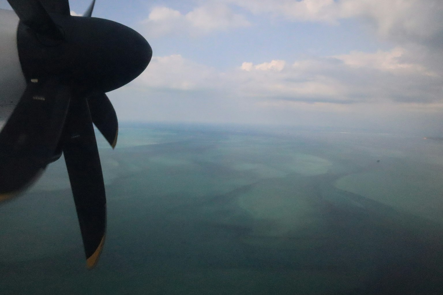 Pemandangan udara dari pesawat propeller di atas laut