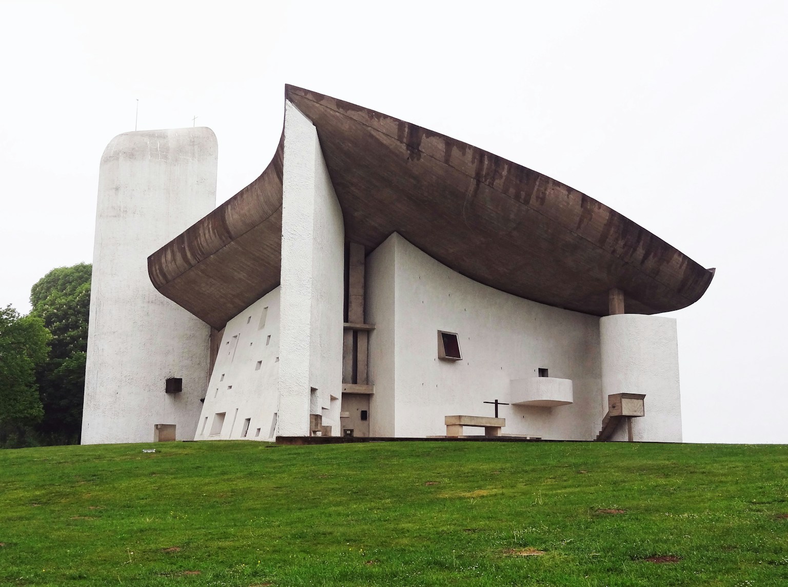 White concrete church designed by Le Corbusier set on green grass