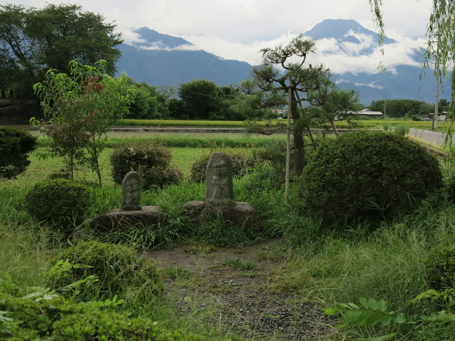 Deux statues en pierre dans un paysage serein entouré de verdure luxuriante