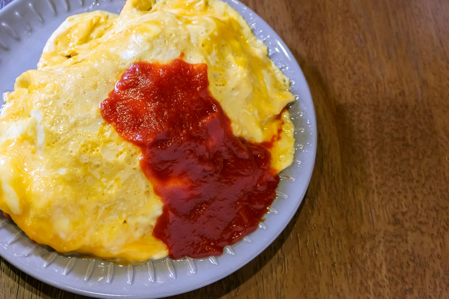 Teller mit Omurice, garniert mit Ketchup