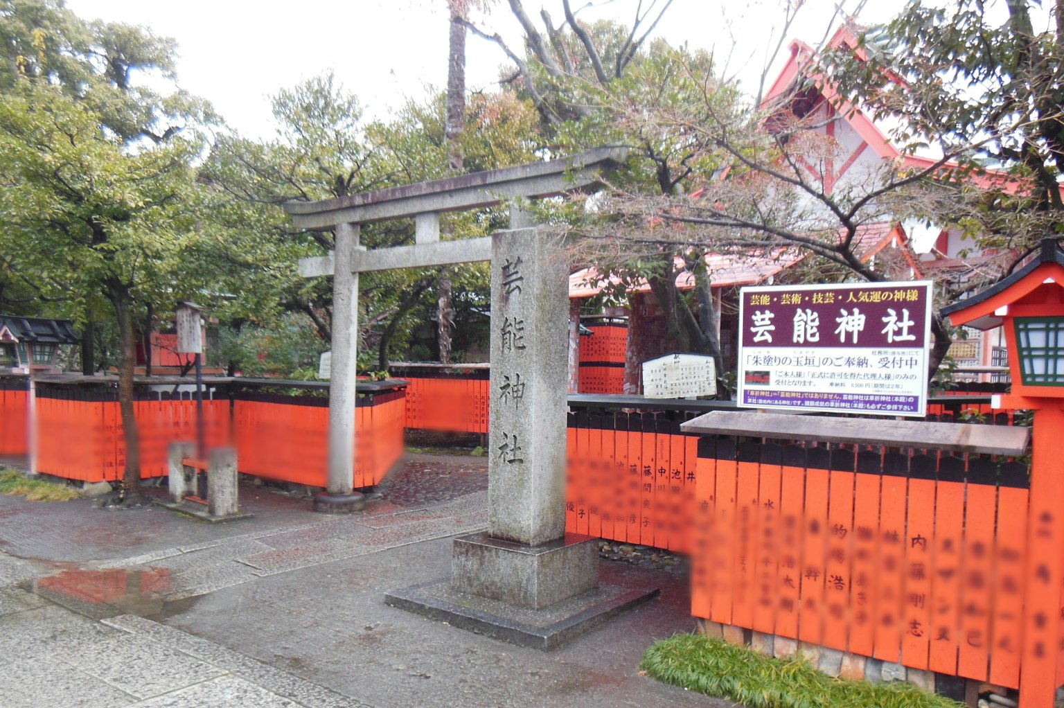 Entrata di un santuario con un torii e una recinzione in legno rosso