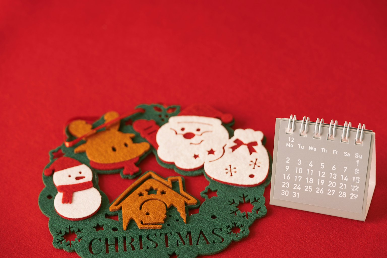 Adegan dengan dekorasi Natal dan kalender di latar belakang merah