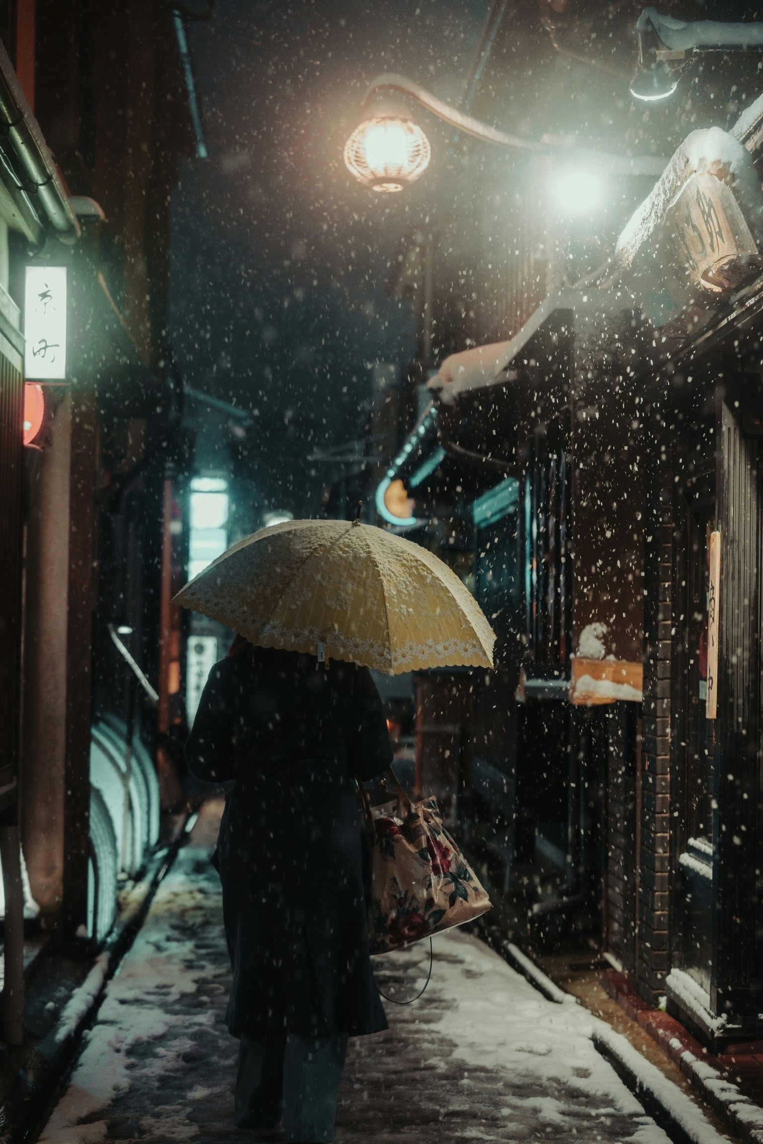 一个人在雪夜的街道上打着伞走