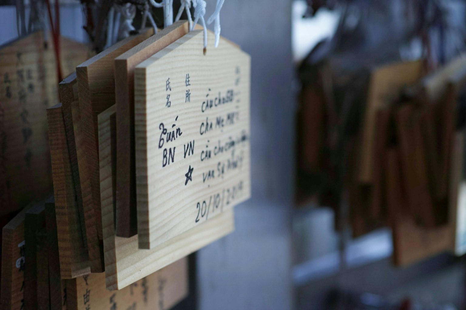 Una vista de placas ema de madera colgadas en un santuario con deseos escritos