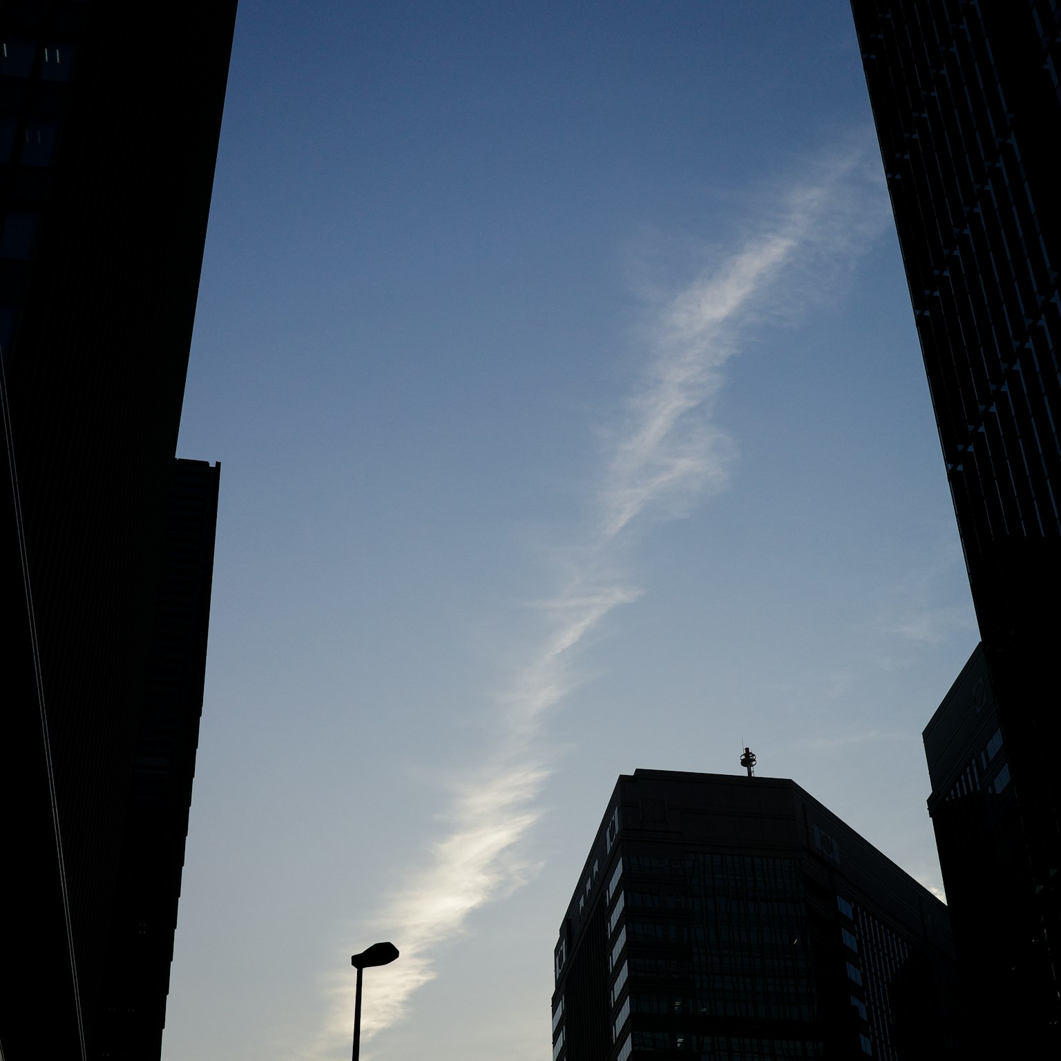 Blick auf den blauen Himmel und Wolken zwischen Gebäuden