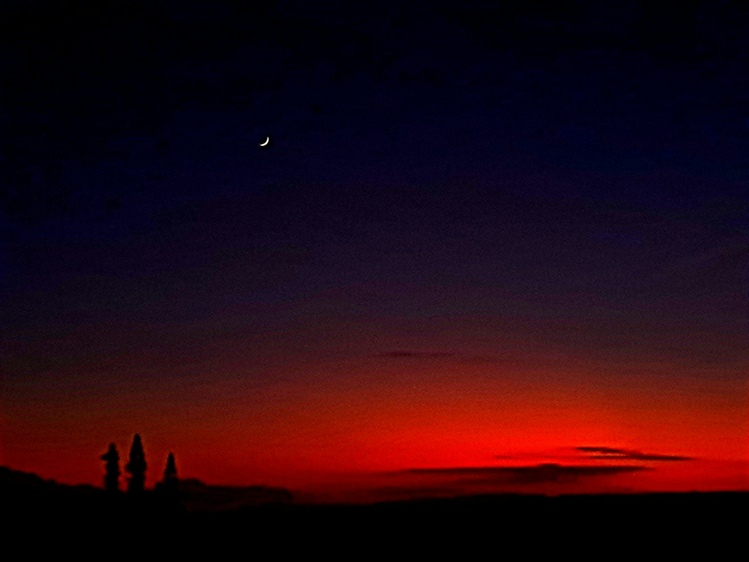 夕陽下的建築輪廓和一彎新月