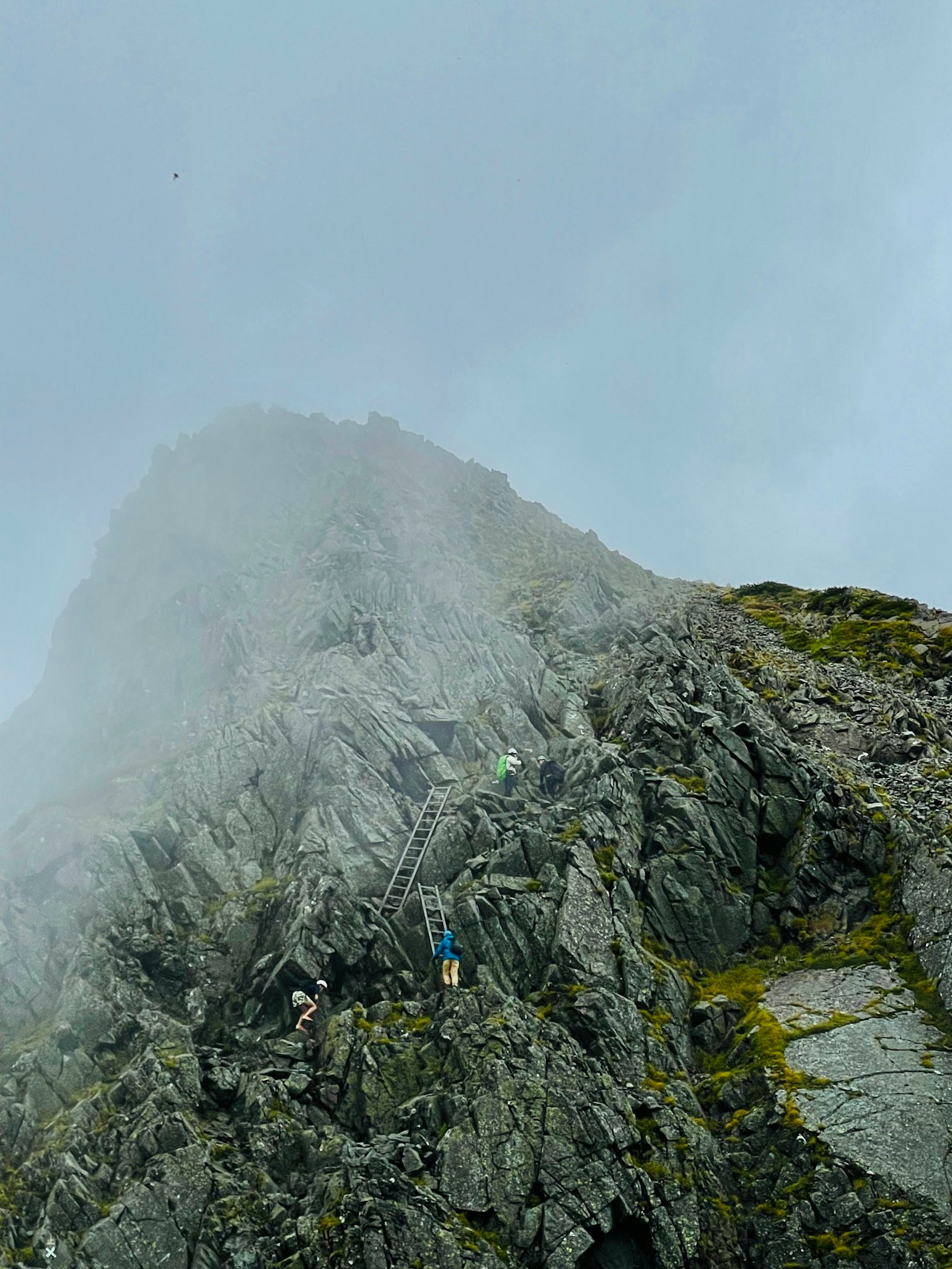 攀登雾蒙蒙的山峰的登山者