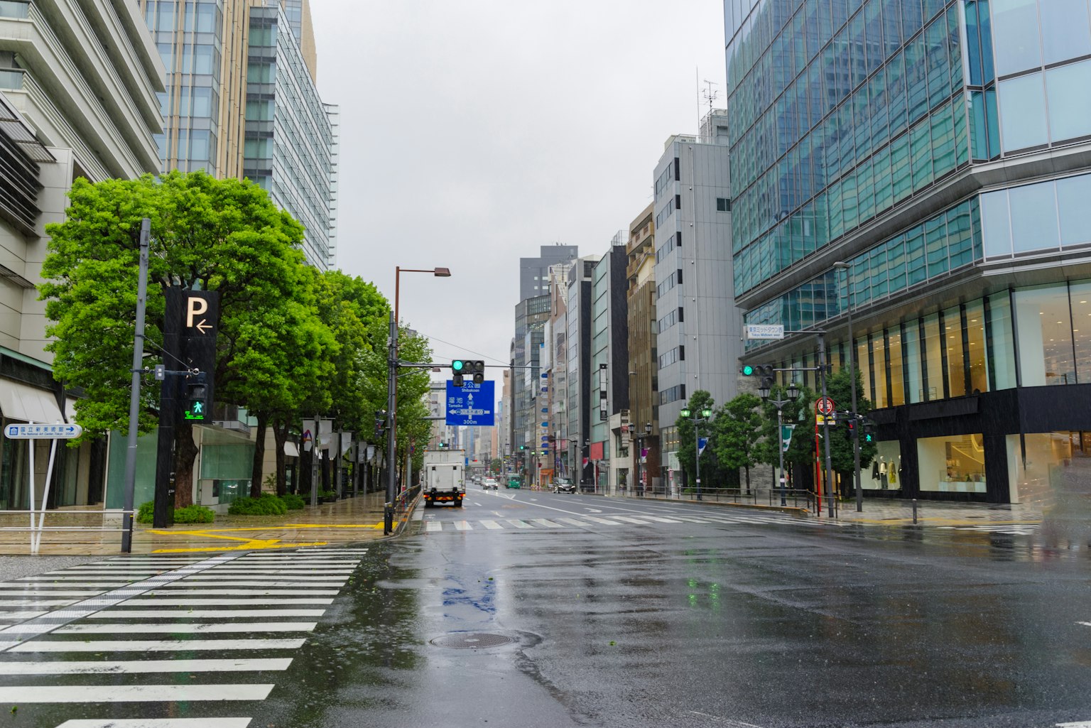 Calle vacía con edificios altos y pavimento mojado