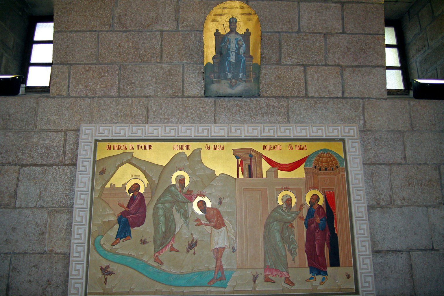 Icono y figuras de santos pintadas en la pared de una iglesia