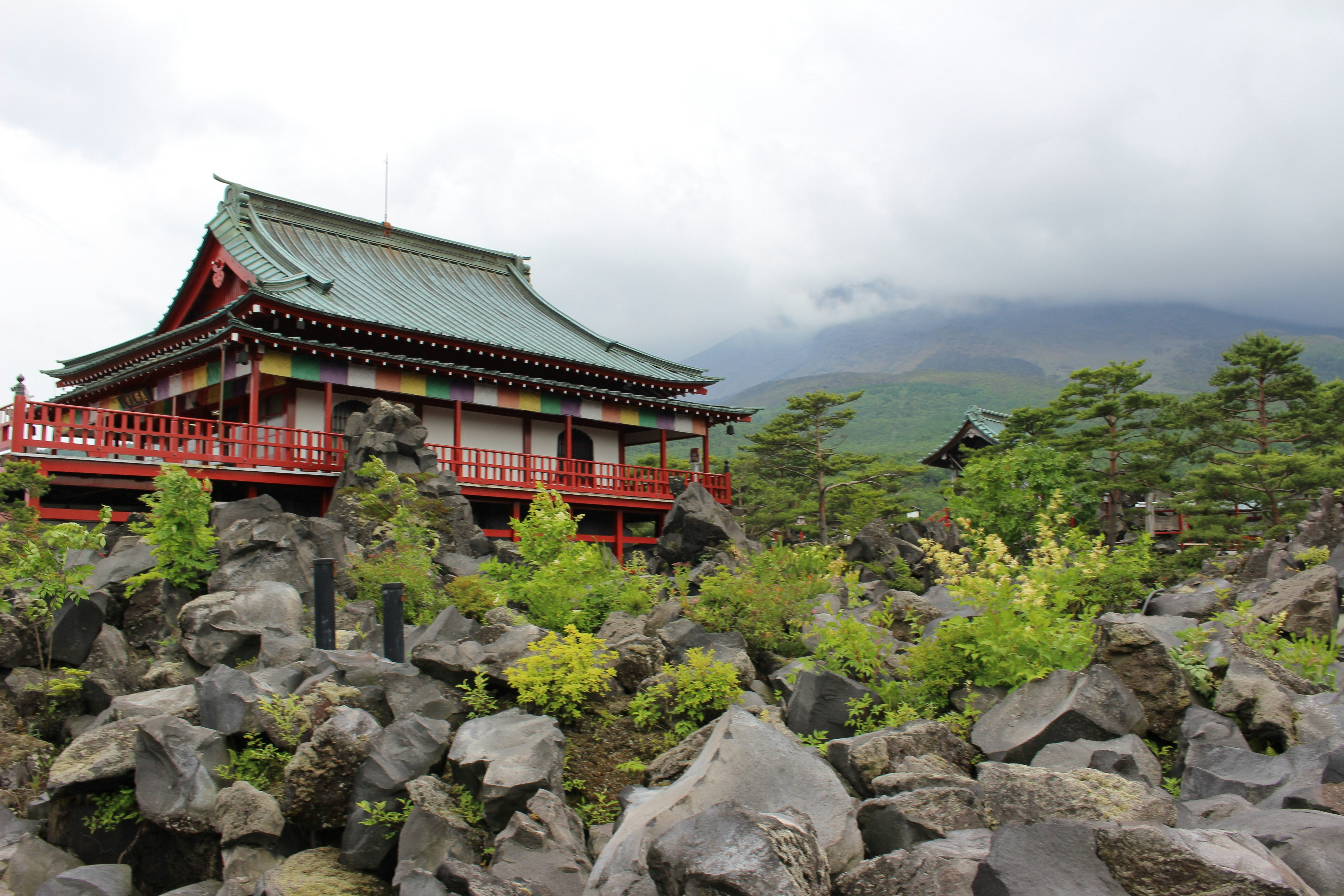 岩石地面上的寺廟建築，綠意與群山景色