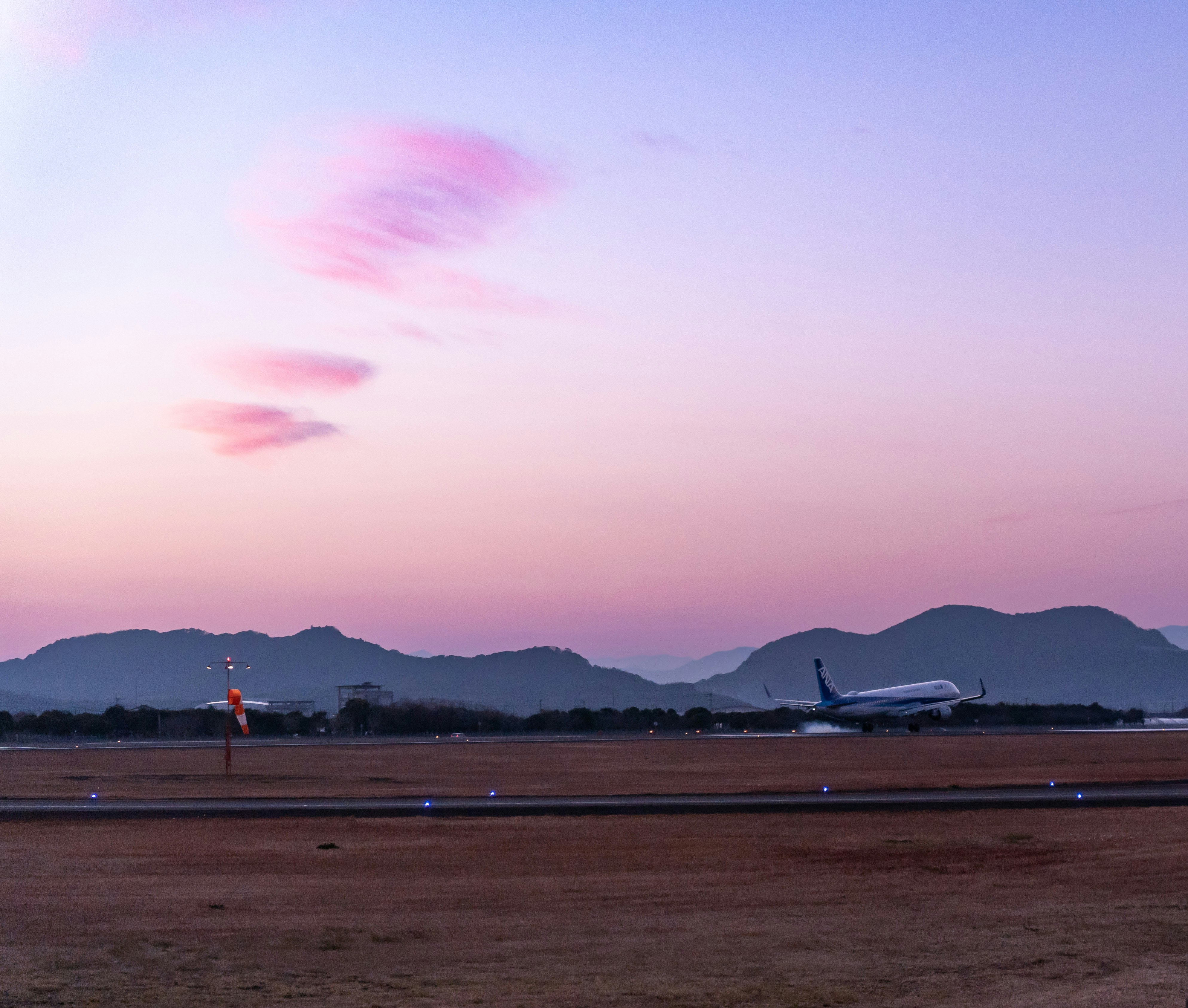 夕暮れの空港滑走路と飛行機のシルエット