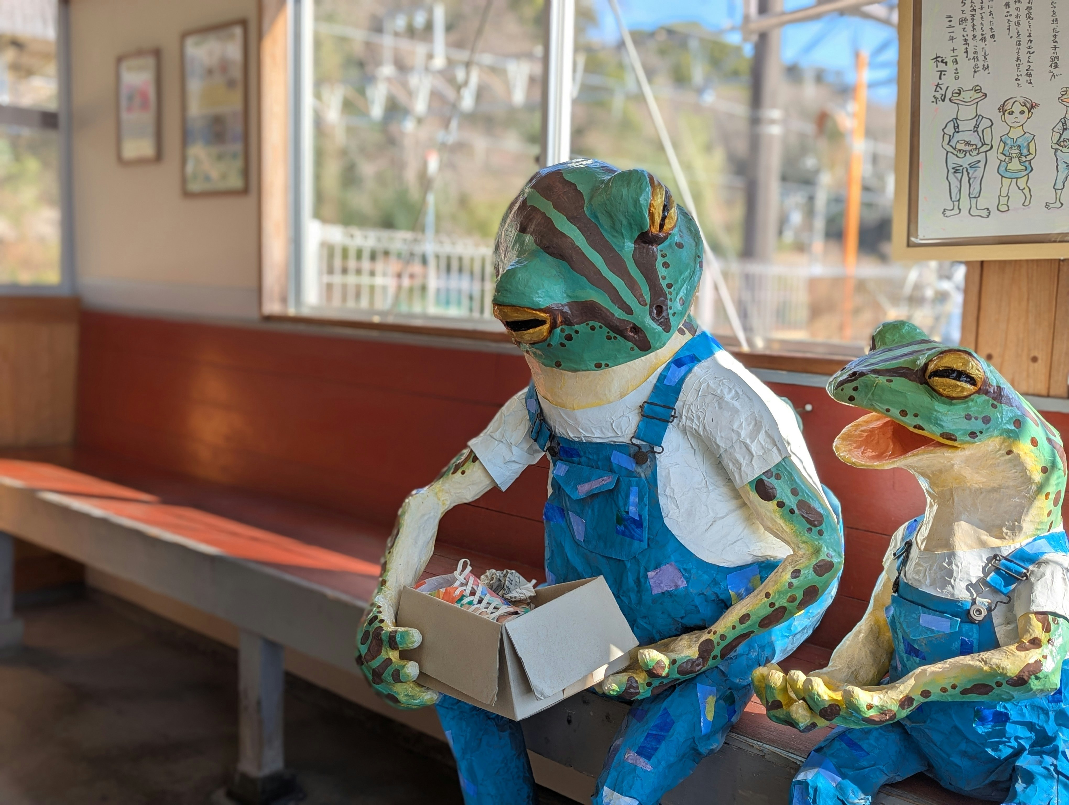 hand-painted style dolls and plush toys holding a box by a window