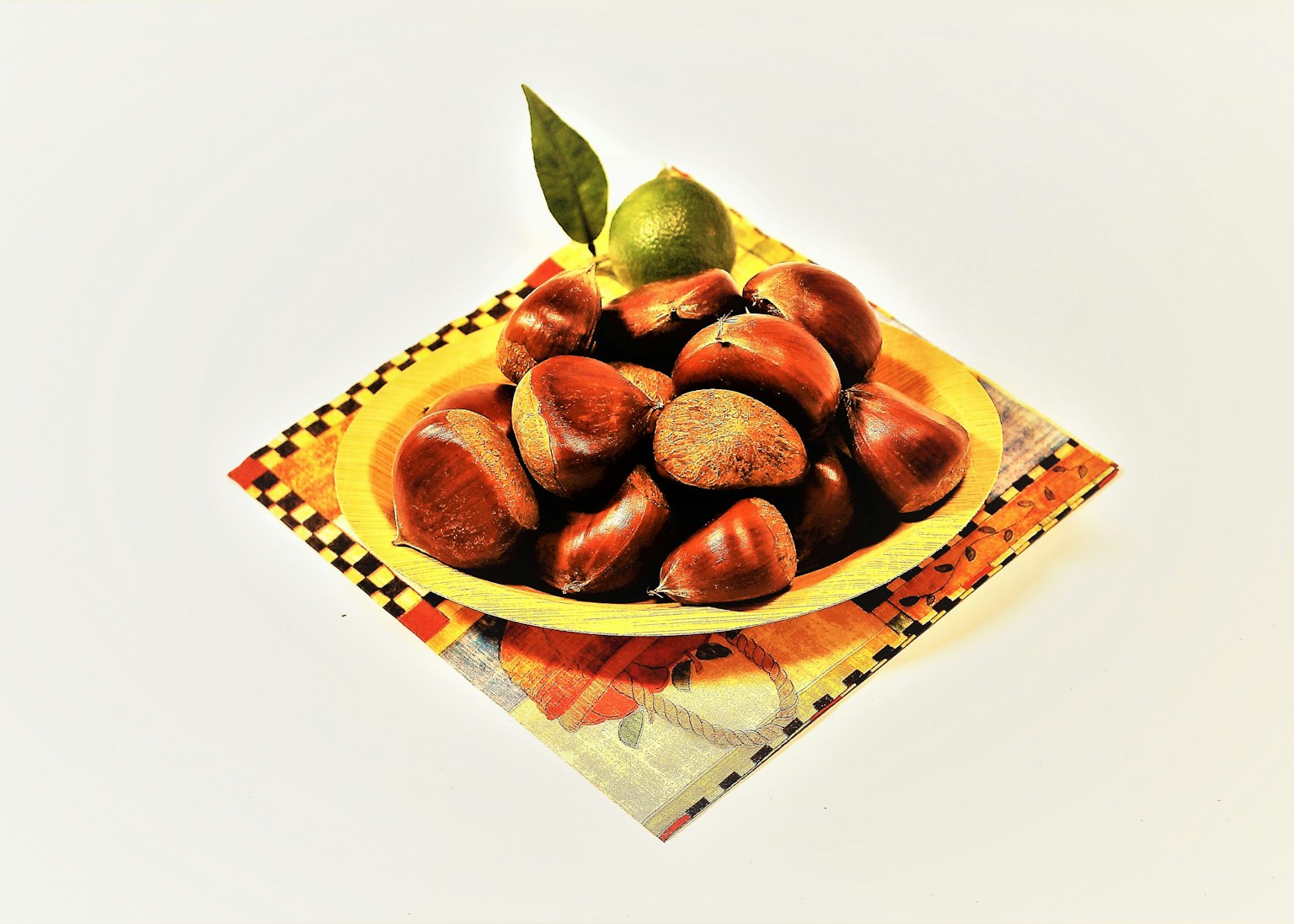 Bol de châtaignes rôties avec des feuilles de citron vert