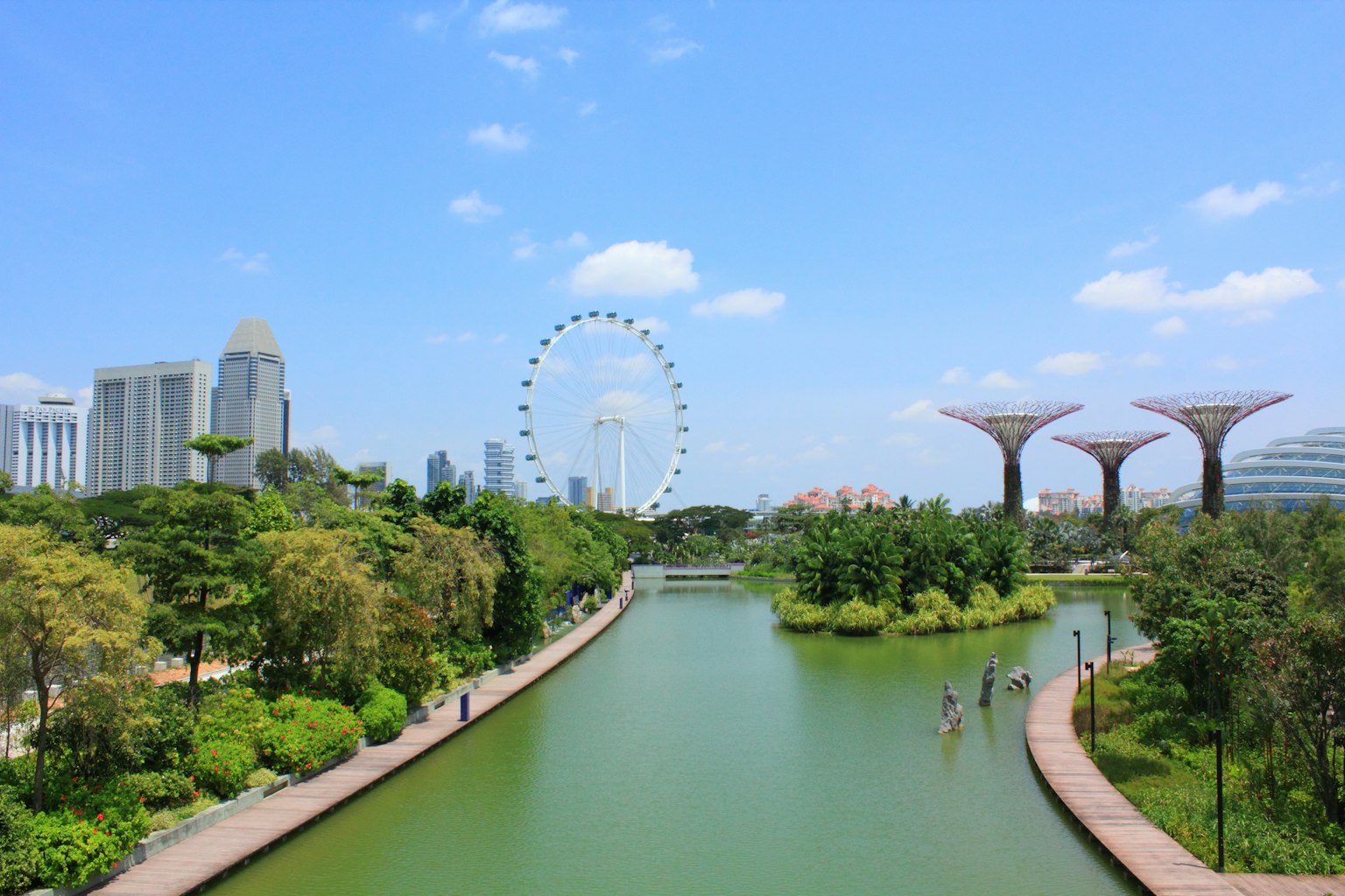 Stadtansicht von Singapur mit einem Fluss und üppigem Grün im Vordergrund
