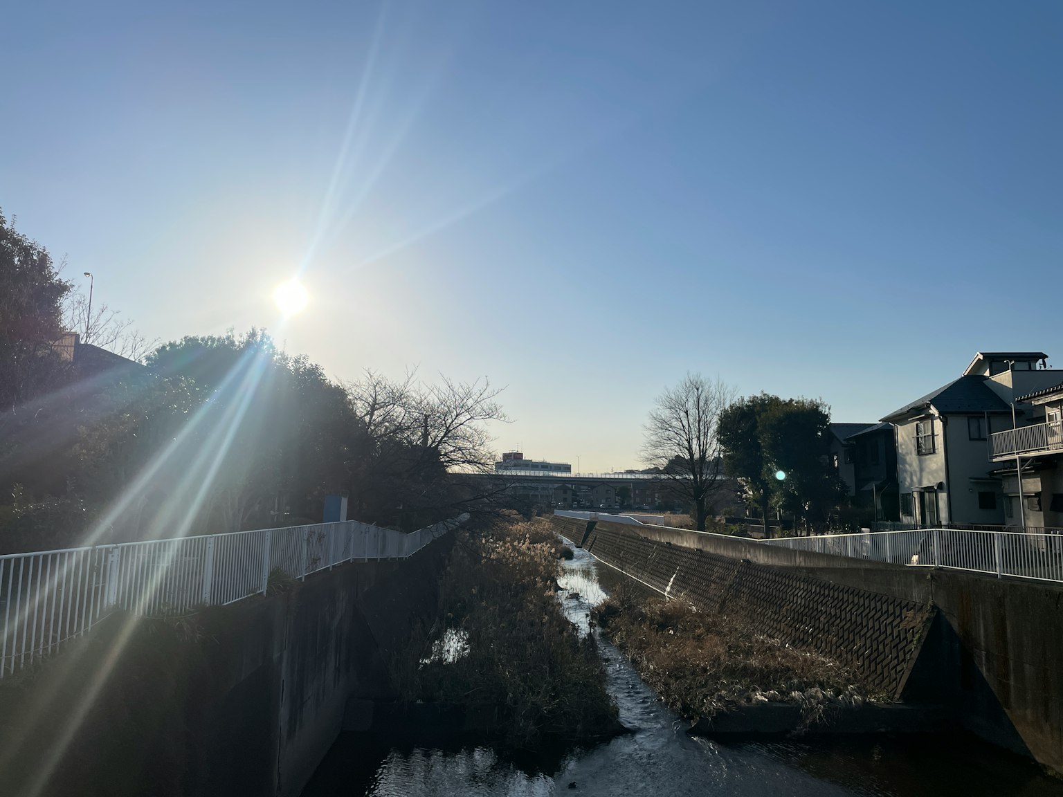 Arroyo bajo un cielo despejado con casas alrededor