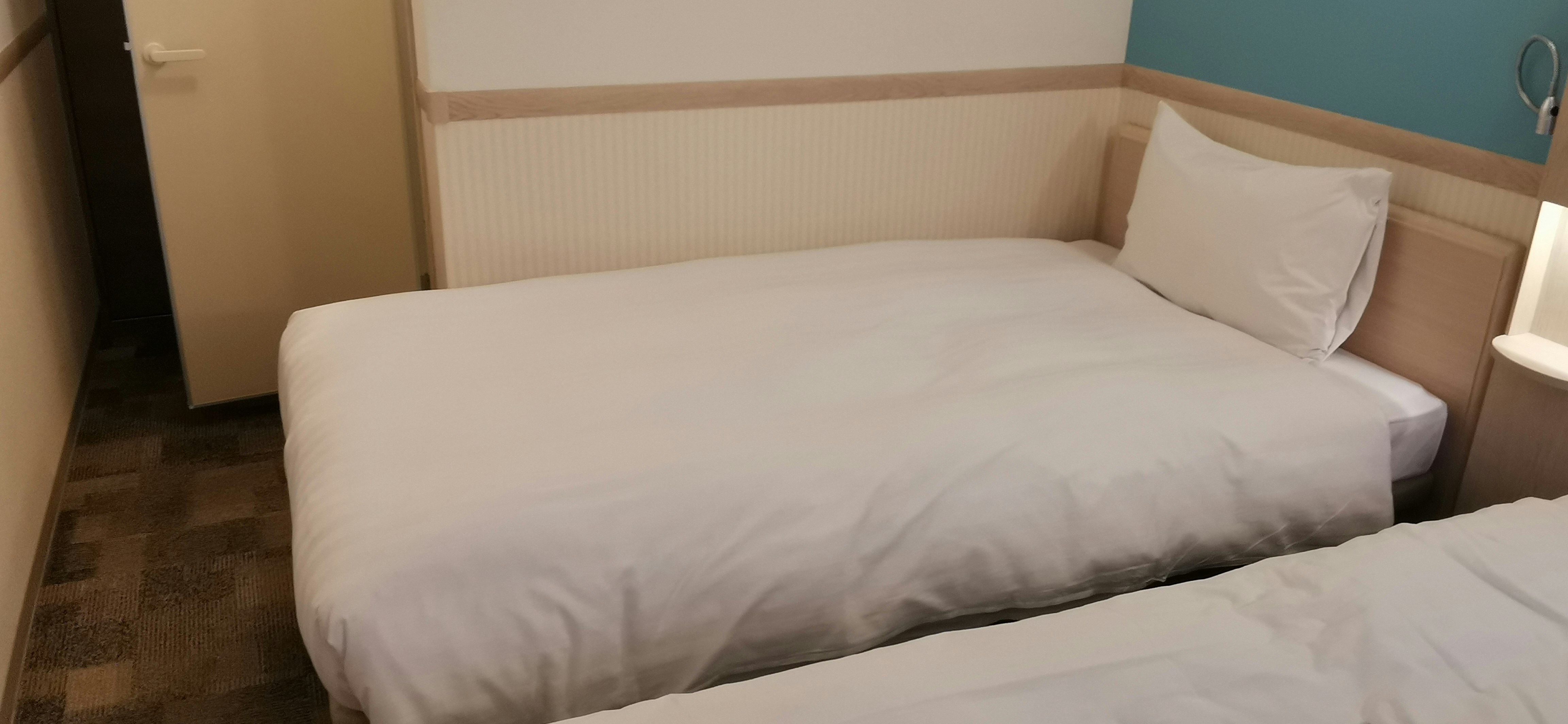 intérieur de chambre d’hôtel avec lit et linge de lit bien faits
