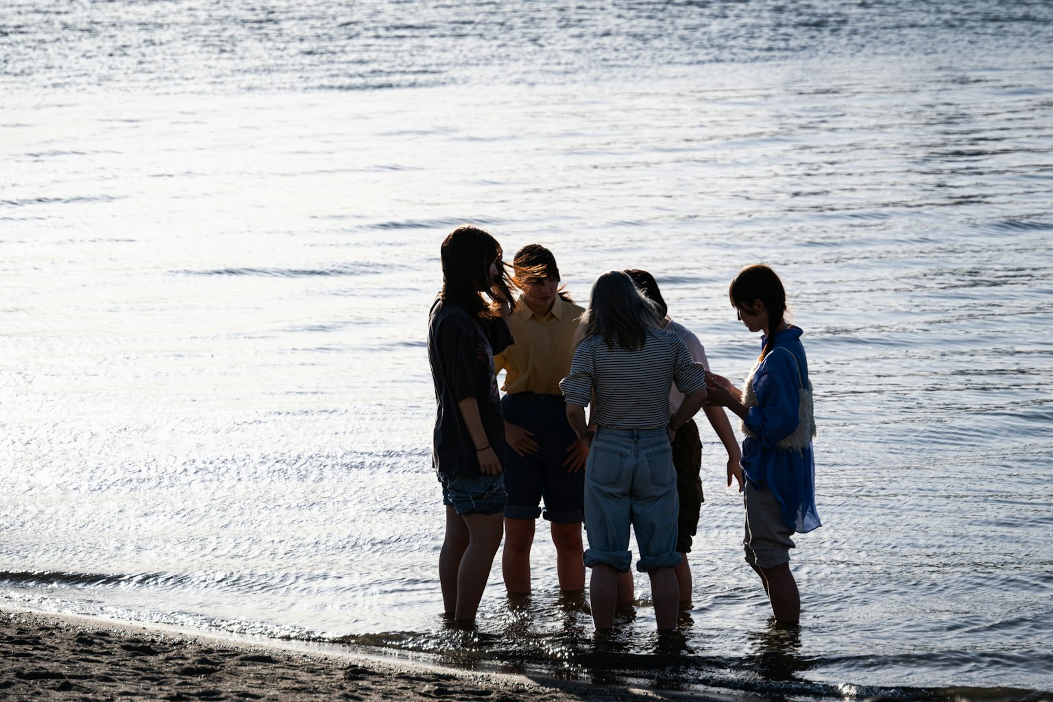 Siluetas de jóvenes reunidos en la playa