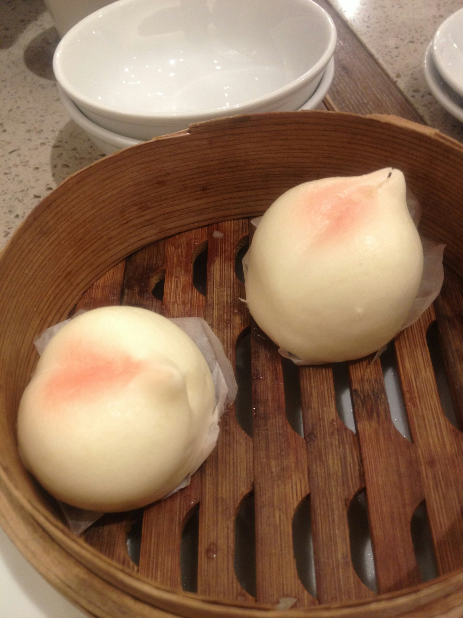 蒸锅中两只白色饺子样的点心的图片