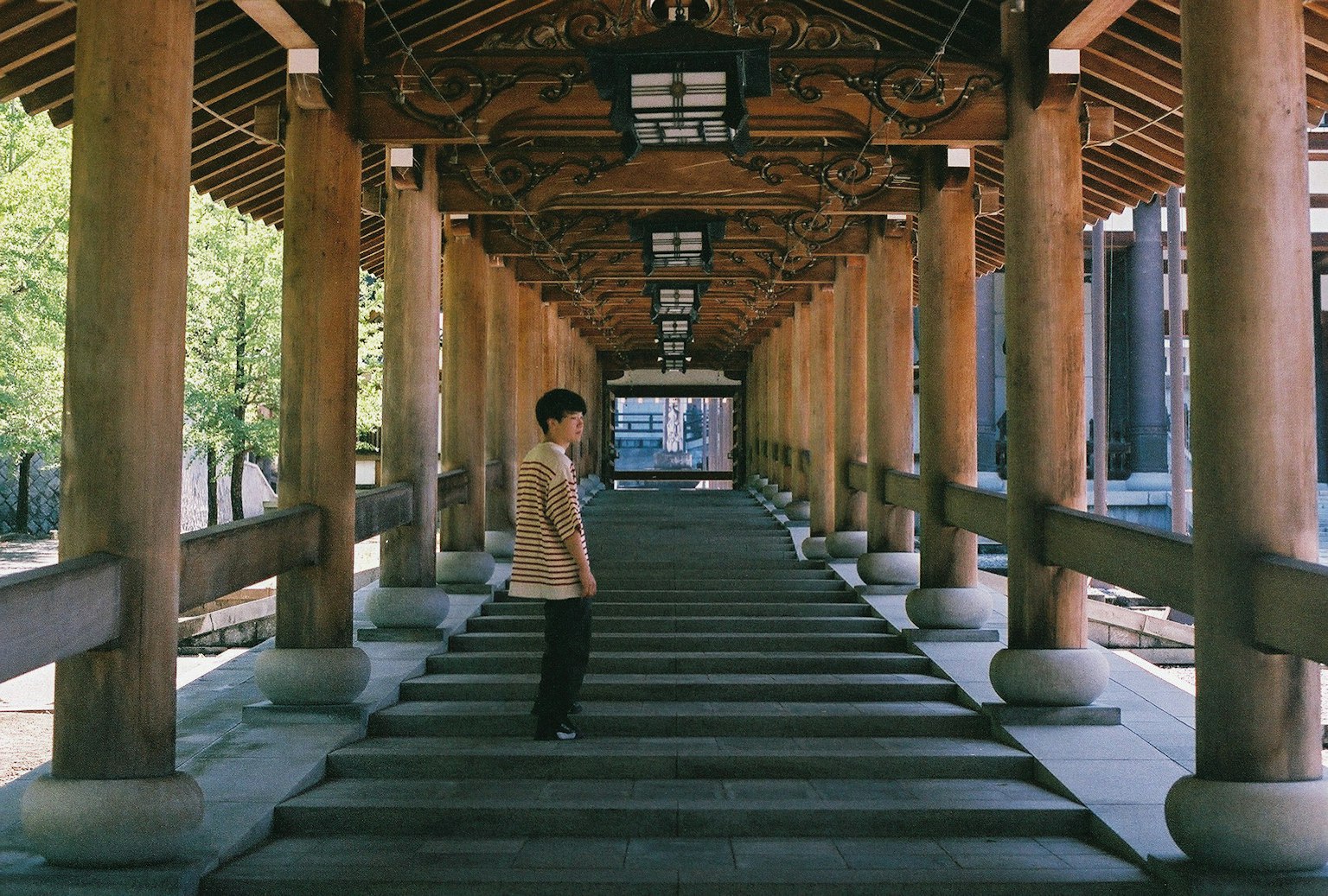 Eine Person steht in einem langen Korridor mit traditioneller japanischer Architektur