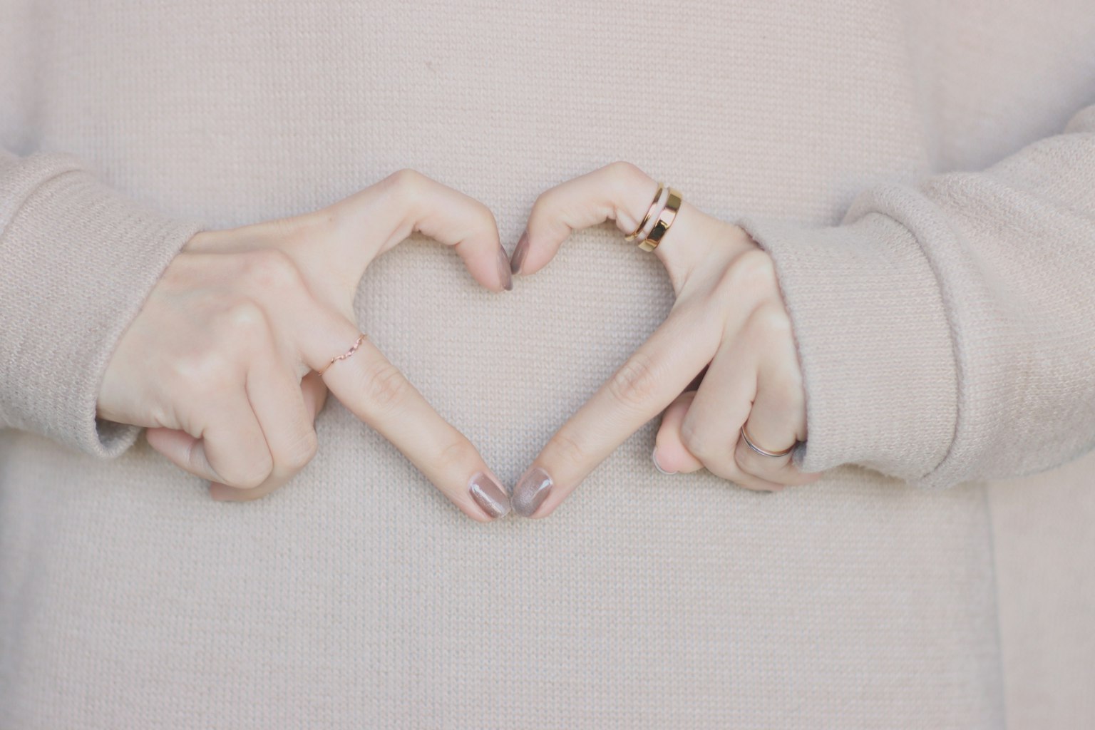 Mani che formano una forma di cuore con anelli