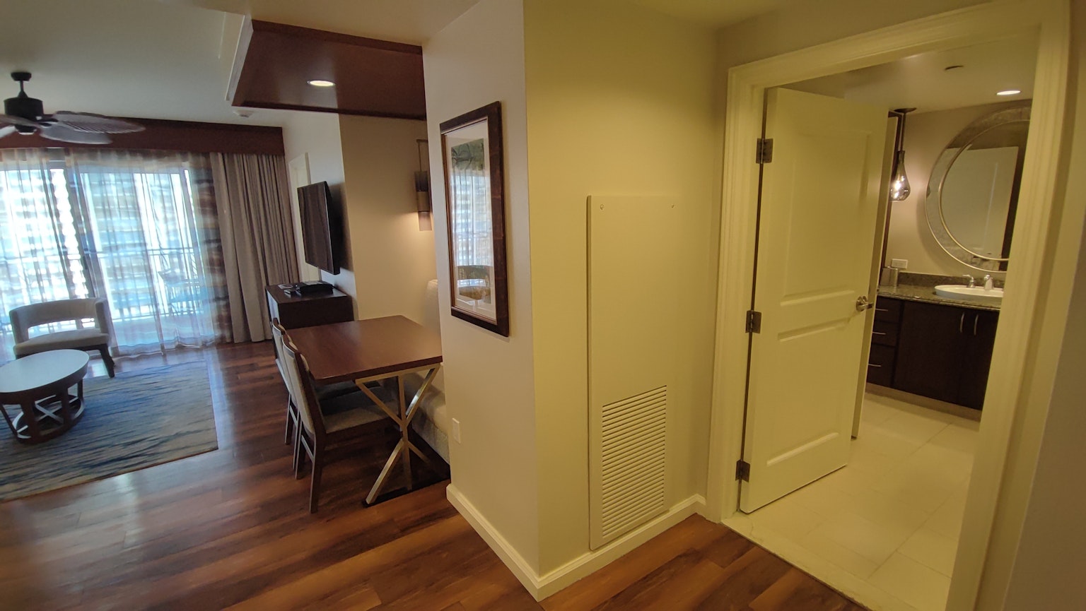 Interior view featuring a bright living room entrance and a door to the bathroom