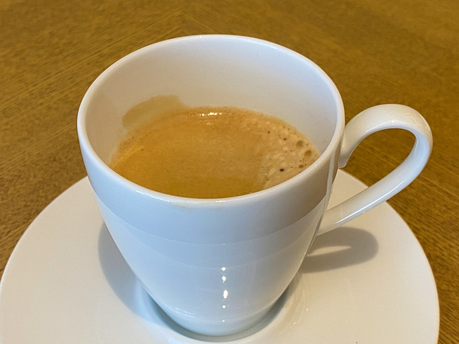 白色杯子裡的濃縮咖啡在碟子上
