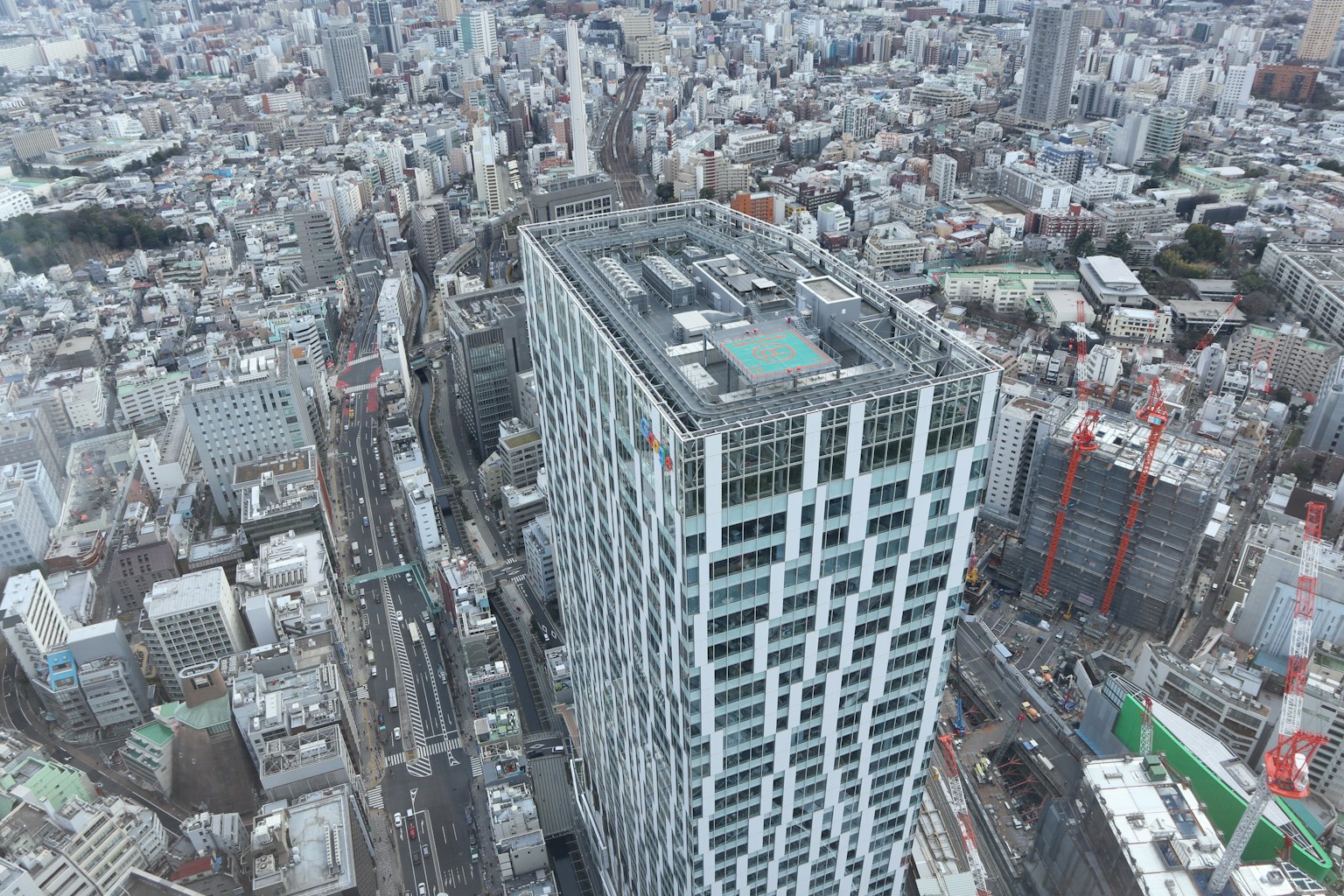 Vue aérienne d'un immeuble élevé entouré d'un paysage urbain avec des routes et des bâtiments