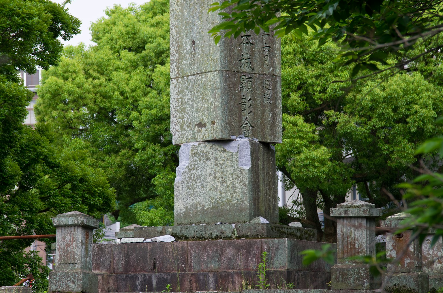 Ein altes Steindenkmal umgeben von grünen Bäumen