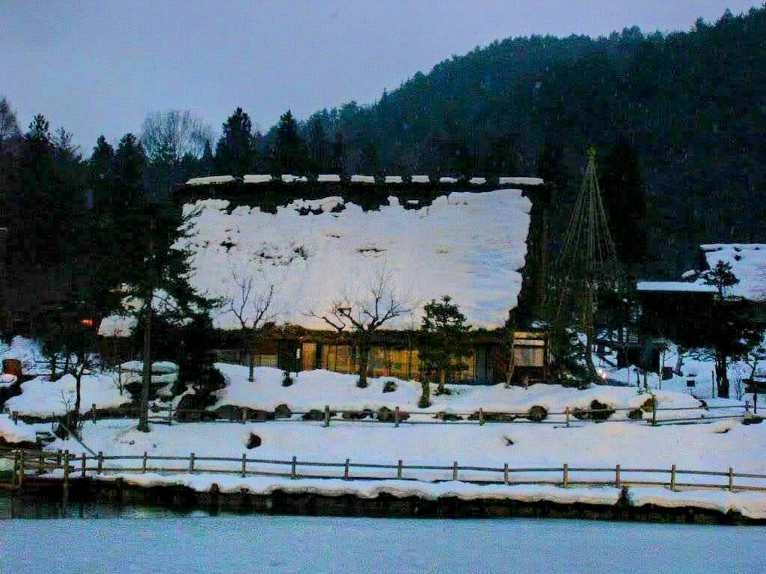 Maison japonaise traditionnelle couverte de neige avec un paysage montagneux