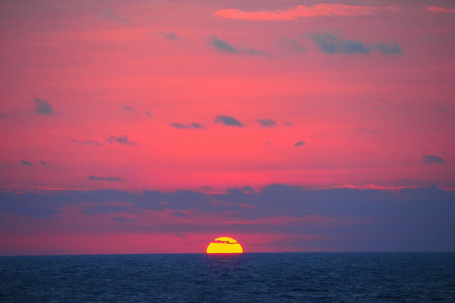 Tramonto sull'oceano con cielo rosa