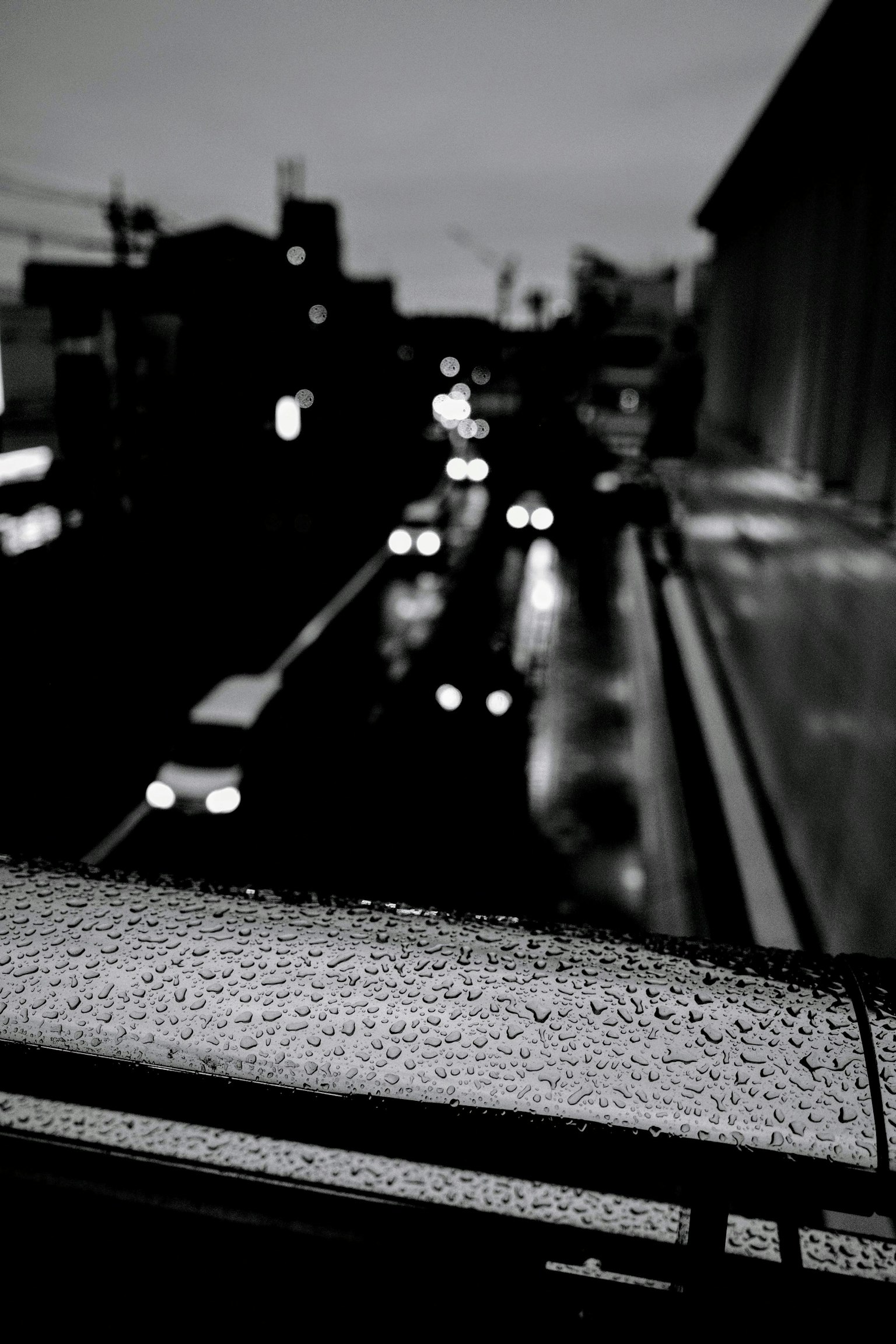 雨水浸濕的欄杆與模糊的城市風景
