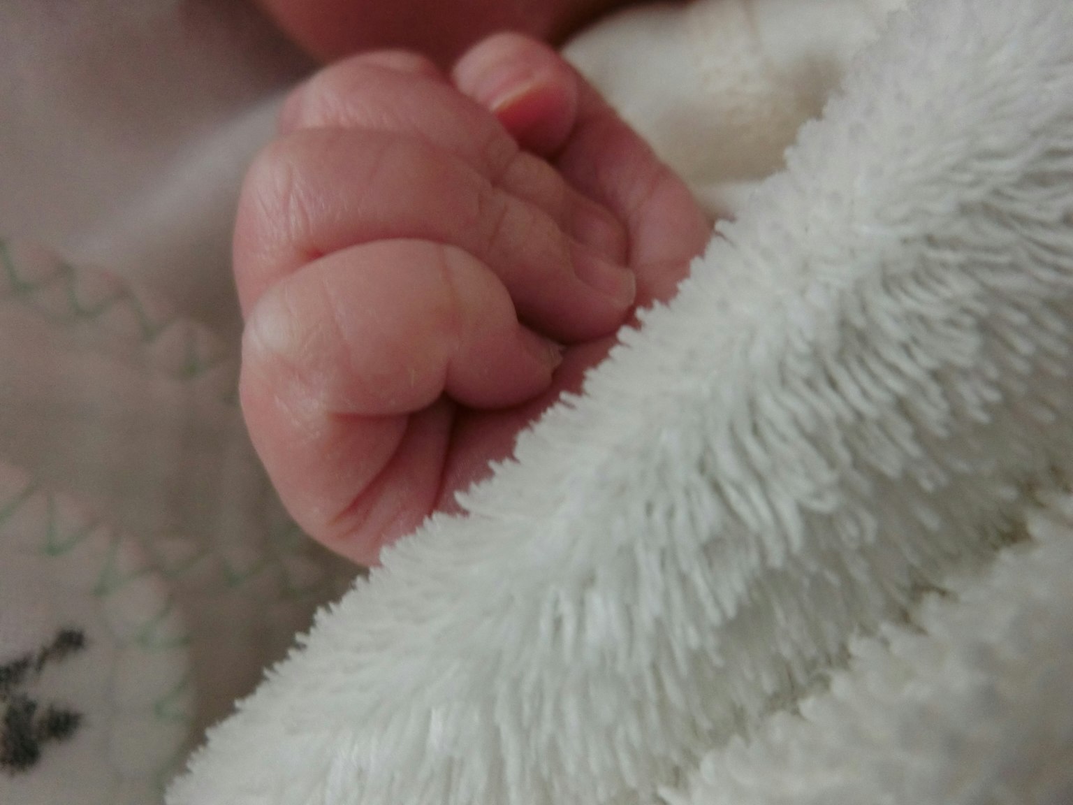 Primo piano di una mano di bambino avvolta in una coperta morbida