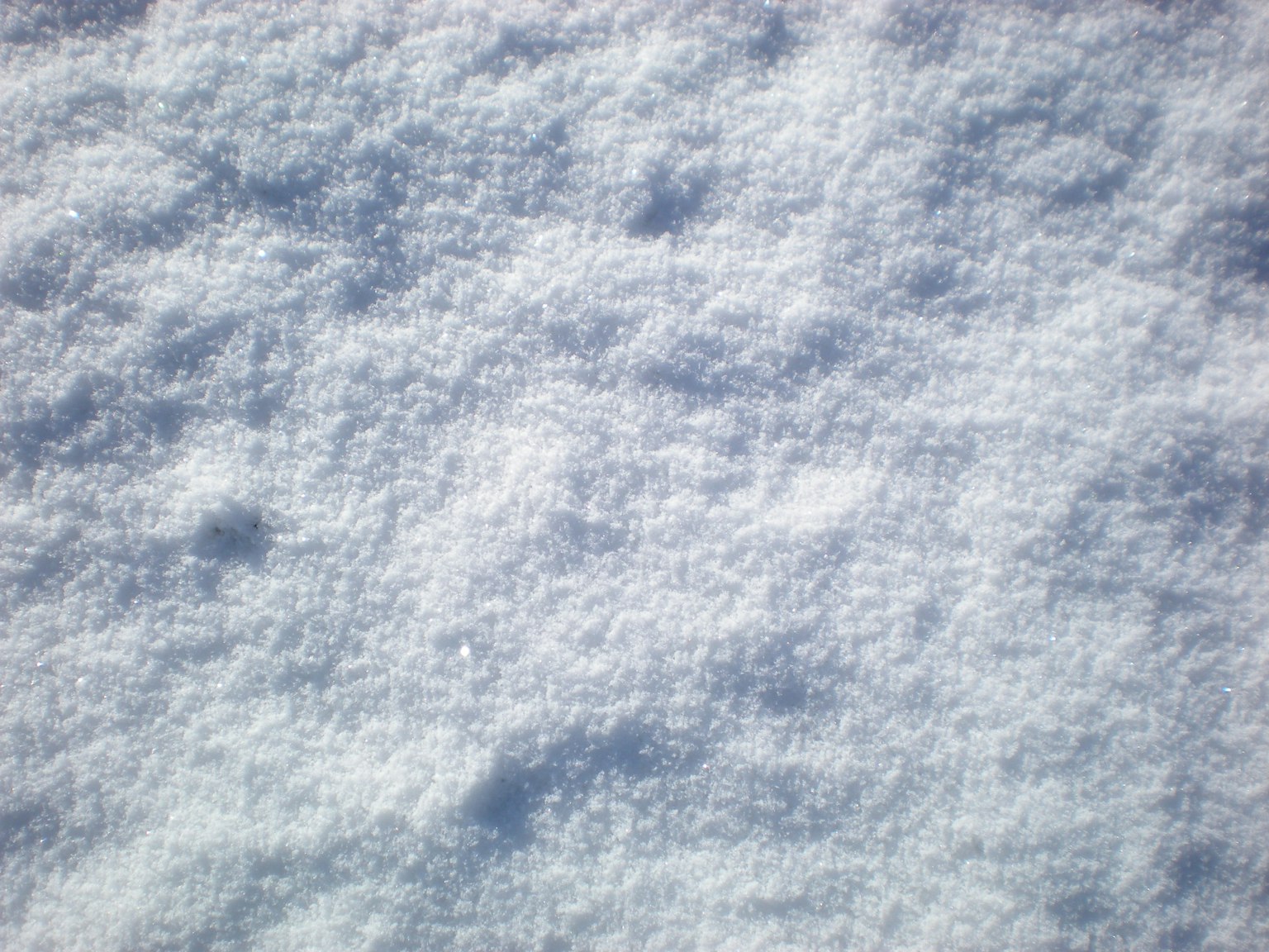 Nahaufnahme einer weichen weißen Schneetextur mit subtilen Variationen