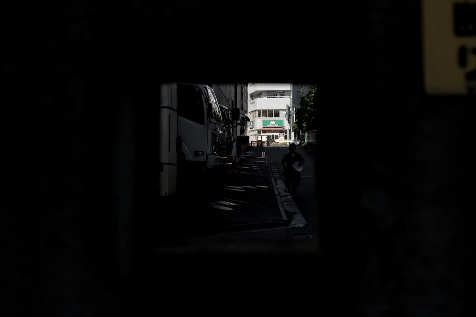 通过黑暗隧道可见的明亮街道和建筑