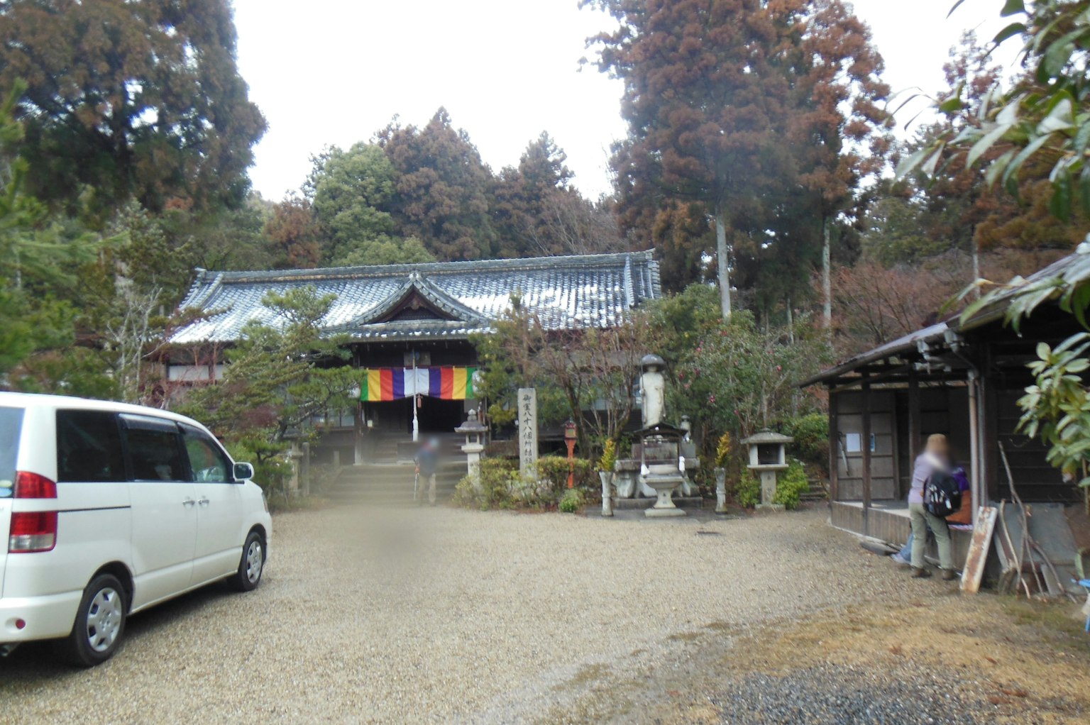 Scène de sanctuaire calme avec une voiture blanche et des drapeaux colorés visibles