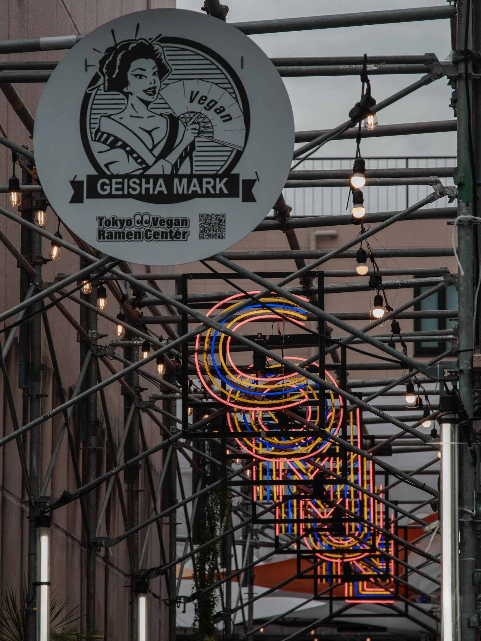 Street featuring Geisha Mark sign and colorful neon lettering