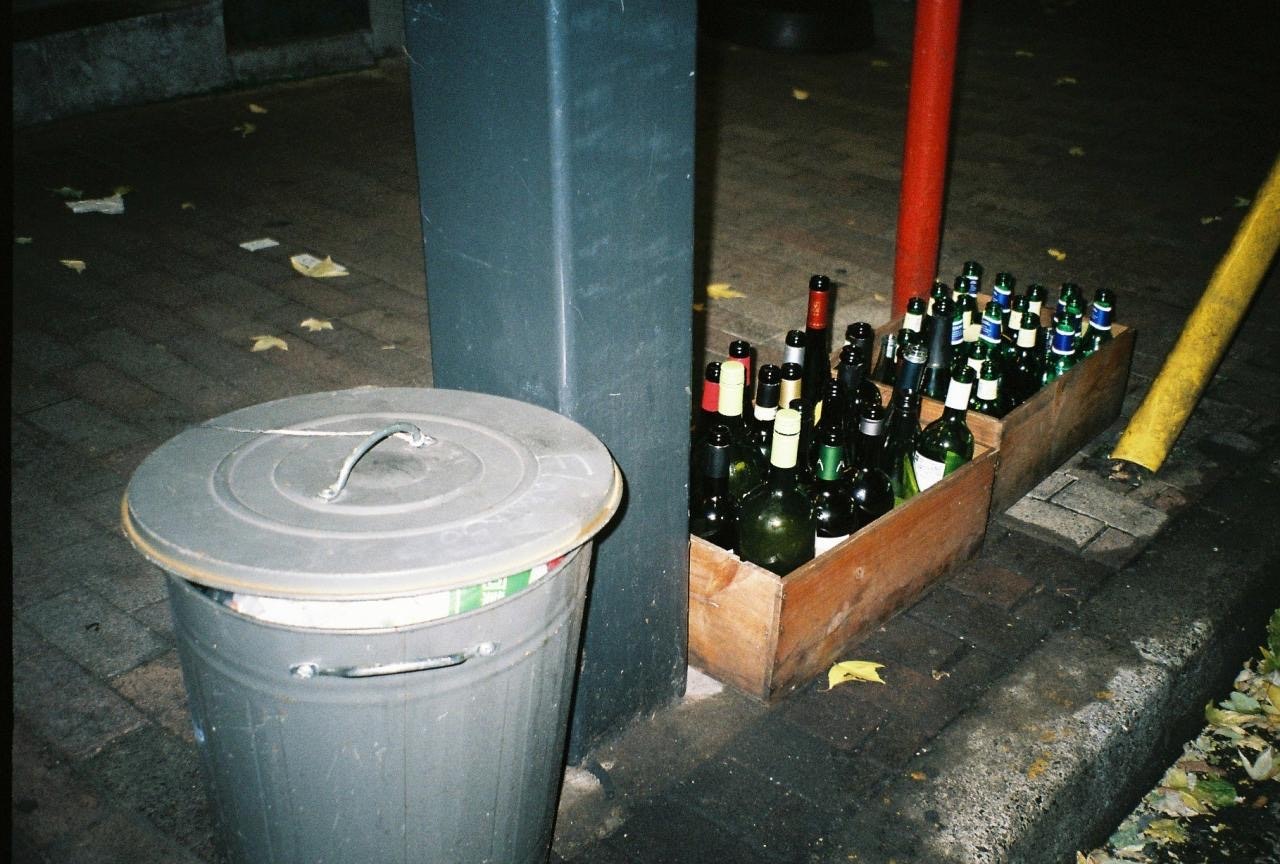 巷子里垃圾桶旁摆放的酒瓶