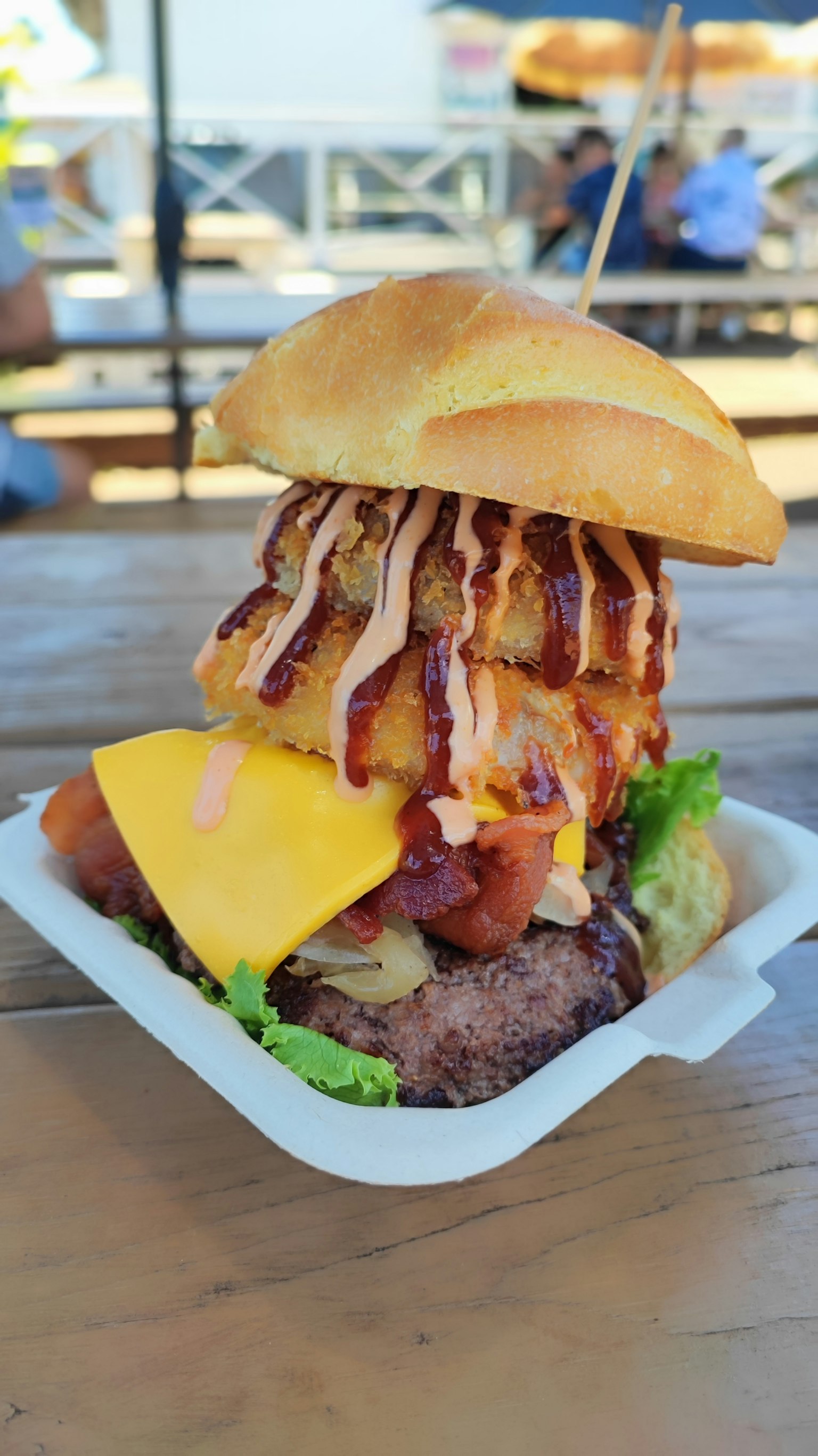 A towering burger with cheese and sauces stacked high